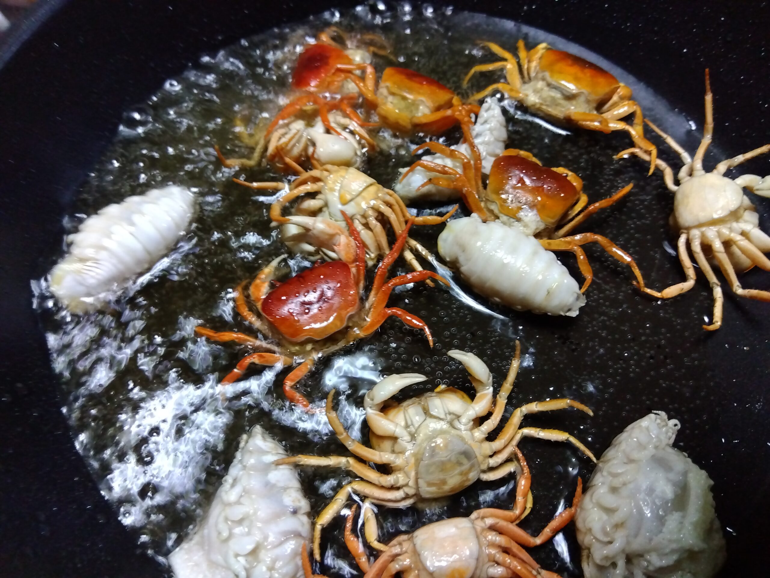 油で素揚げしているサワガニとウオノエ