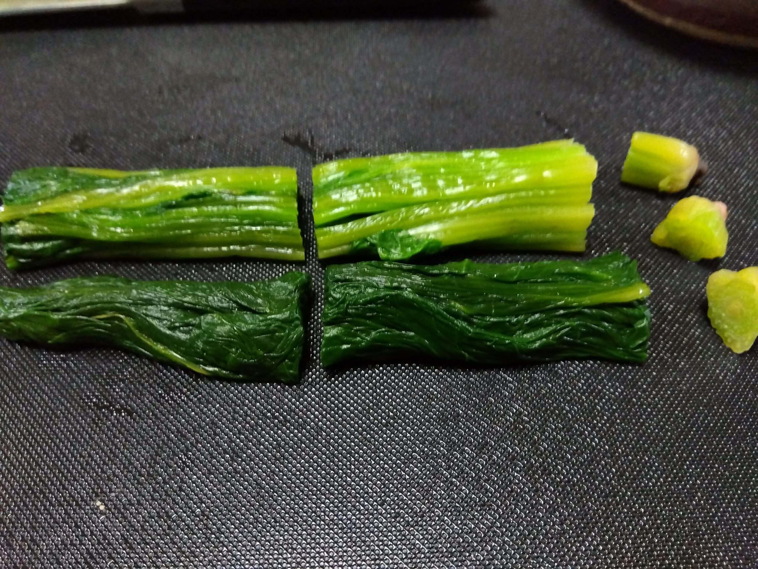 茹でたほうれん草を切っている