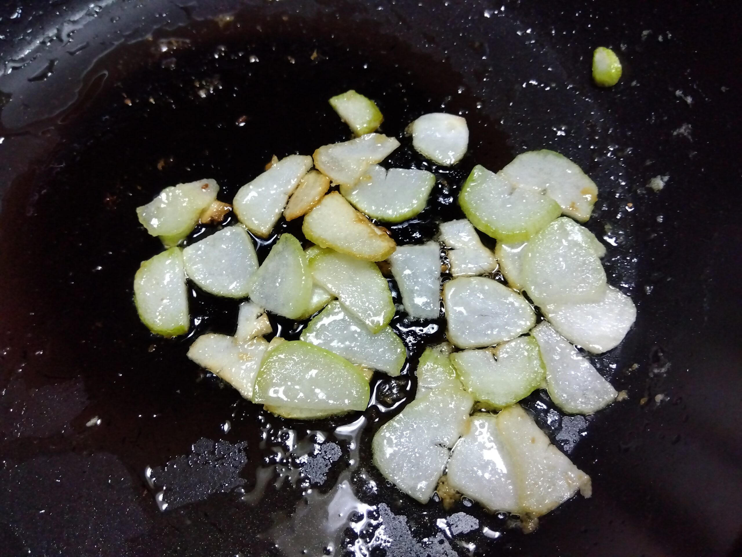 カットしたにんにくを炒めている