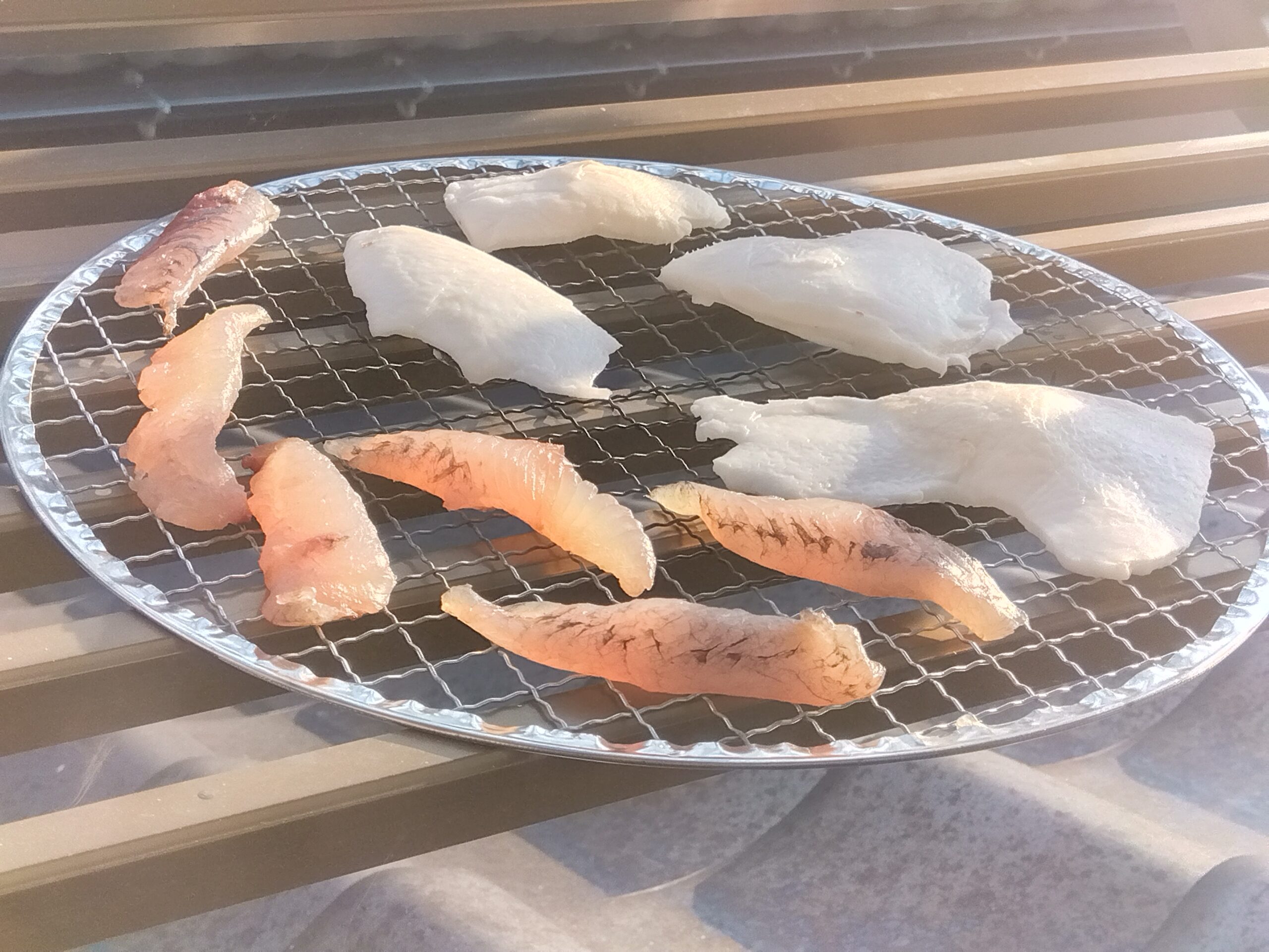 天日干ししているヤングココナッツとトビウオの切り身