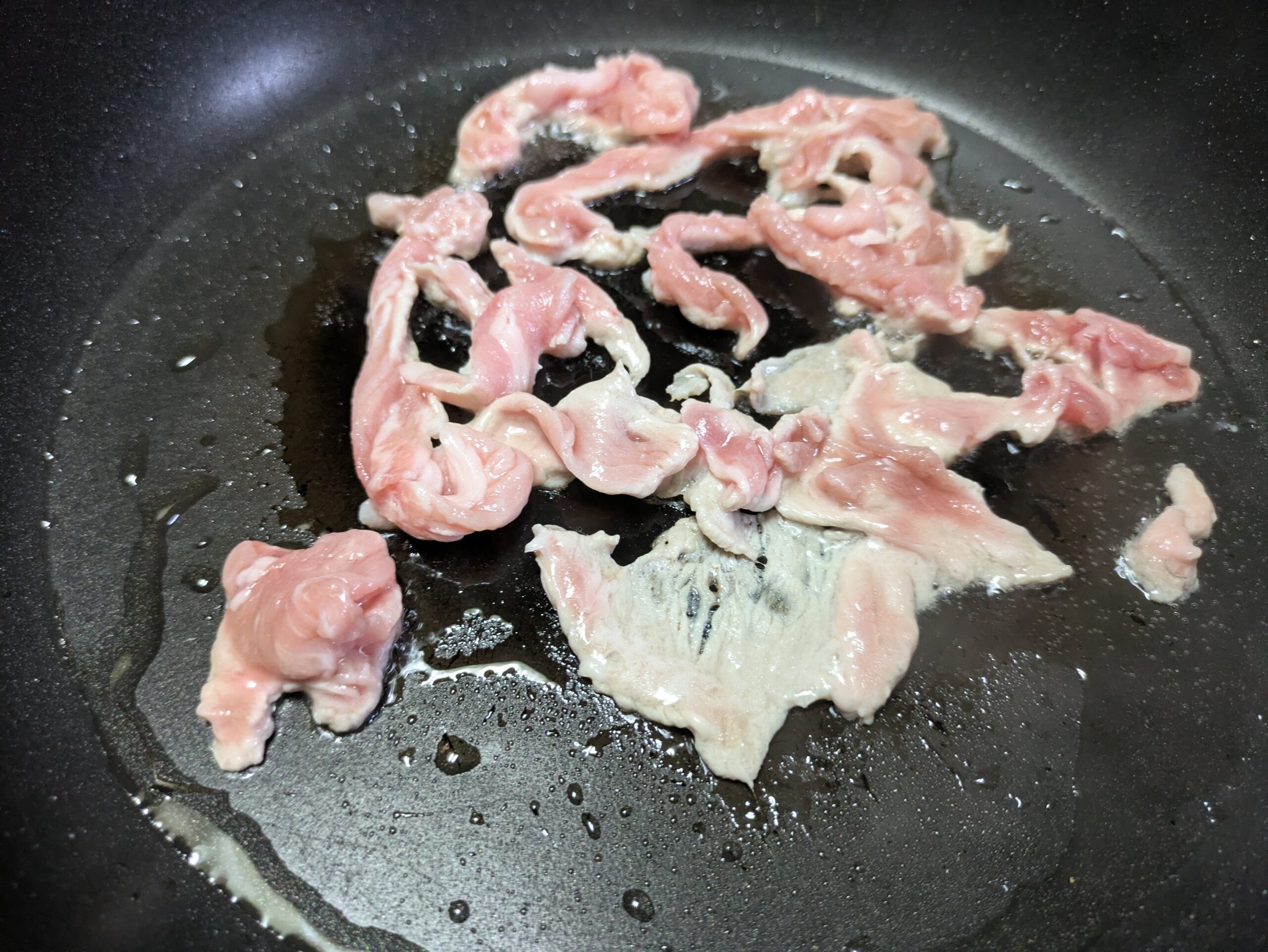 フライパンに並べて焼いている豚小間肉50ｇ