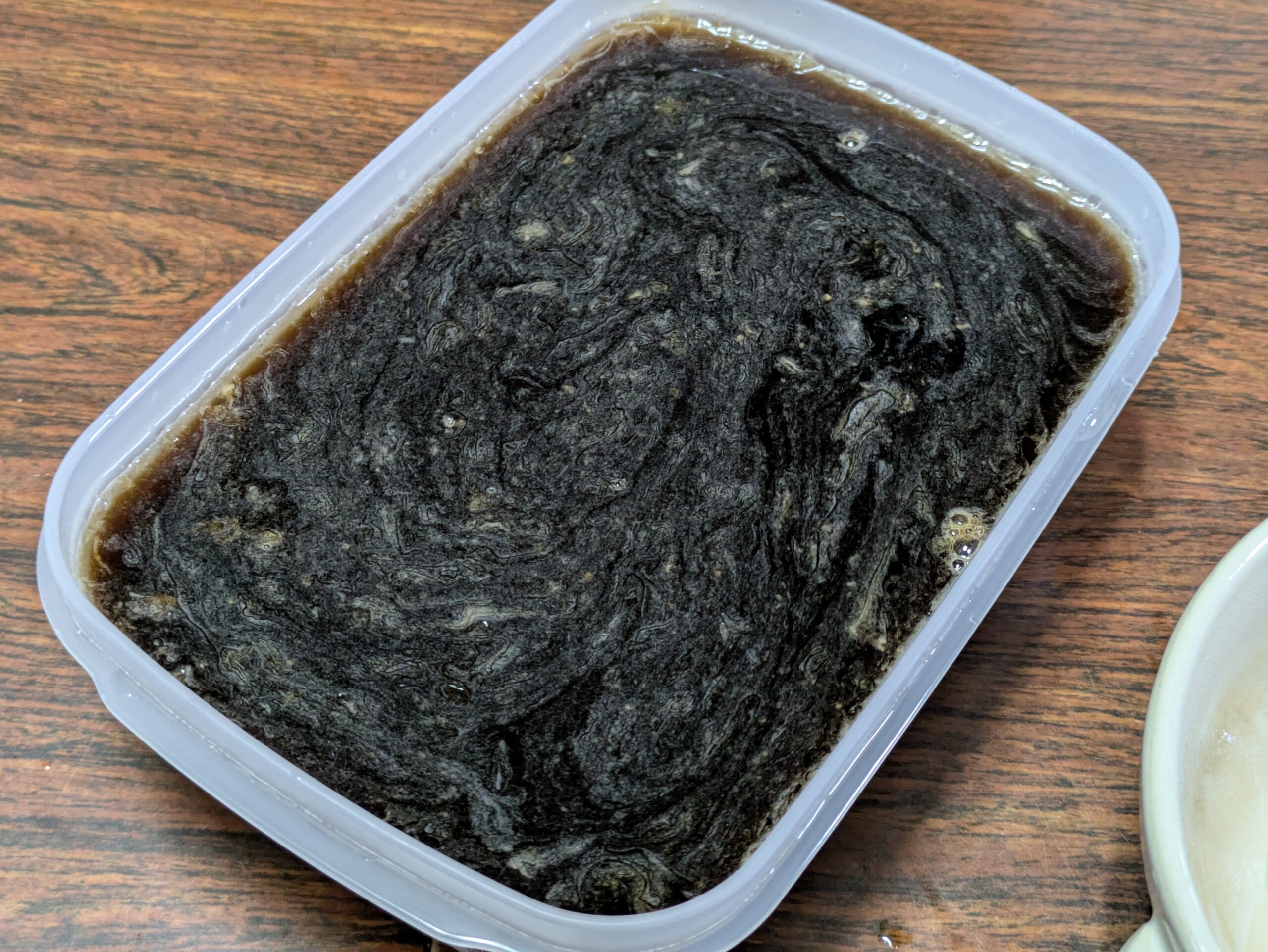 タッパーにコーヒー、溶かしたゼラチン、ナタデココを混ぜたものを入れた