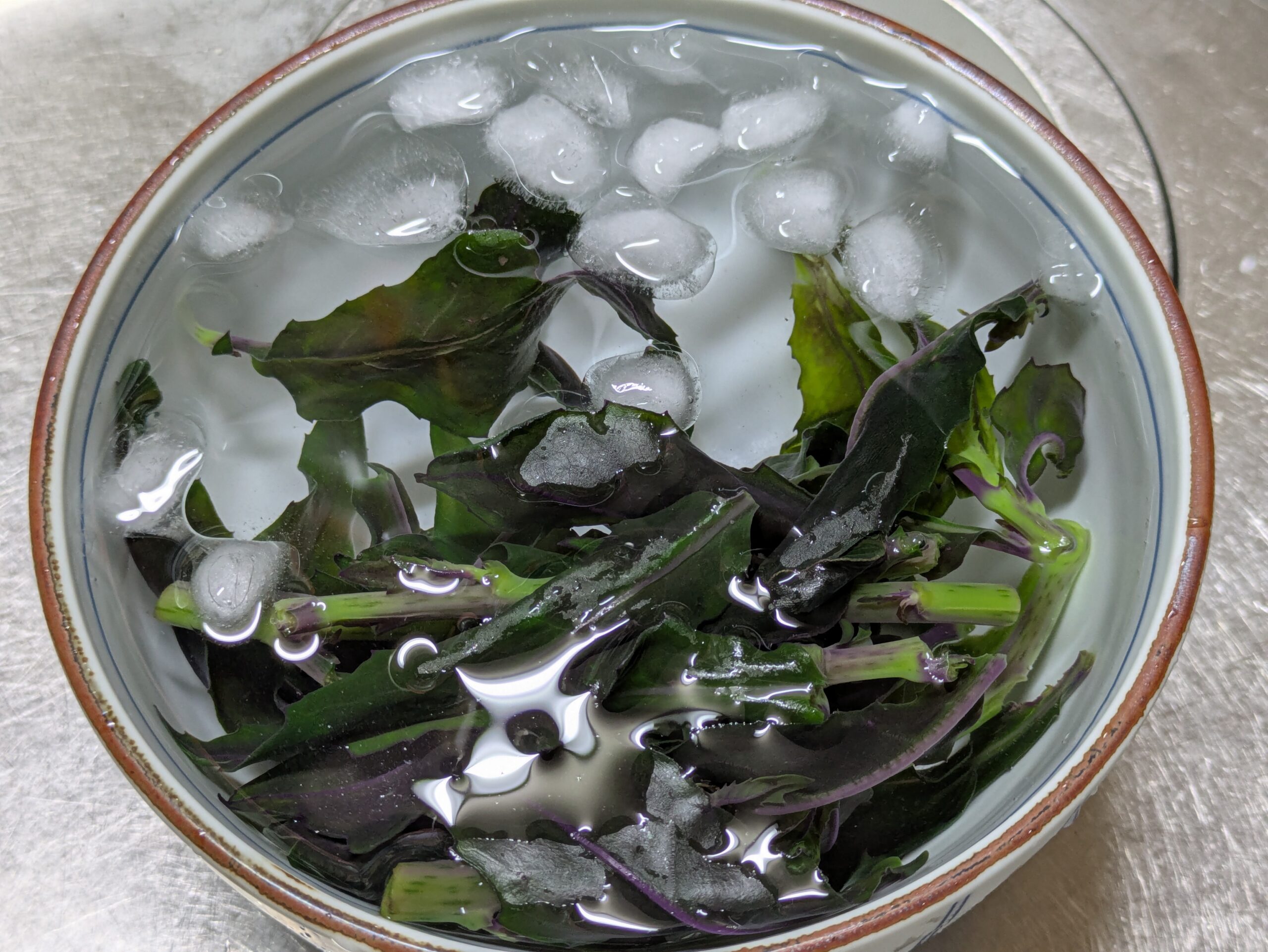 茹でた金時草を冷水に入れて冷ましている様子