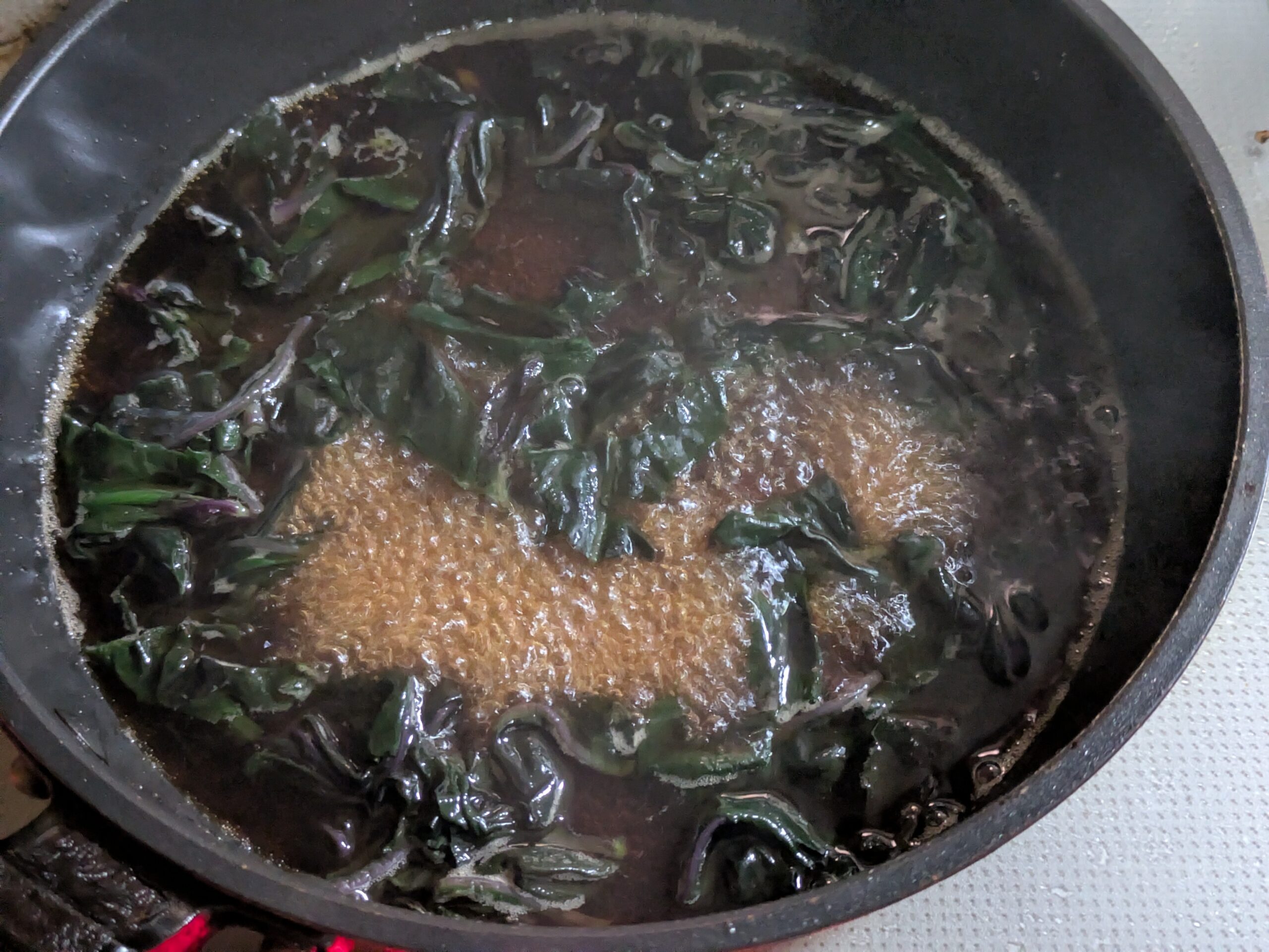 醤油とだしの煮汁で金時草を煮ている様子