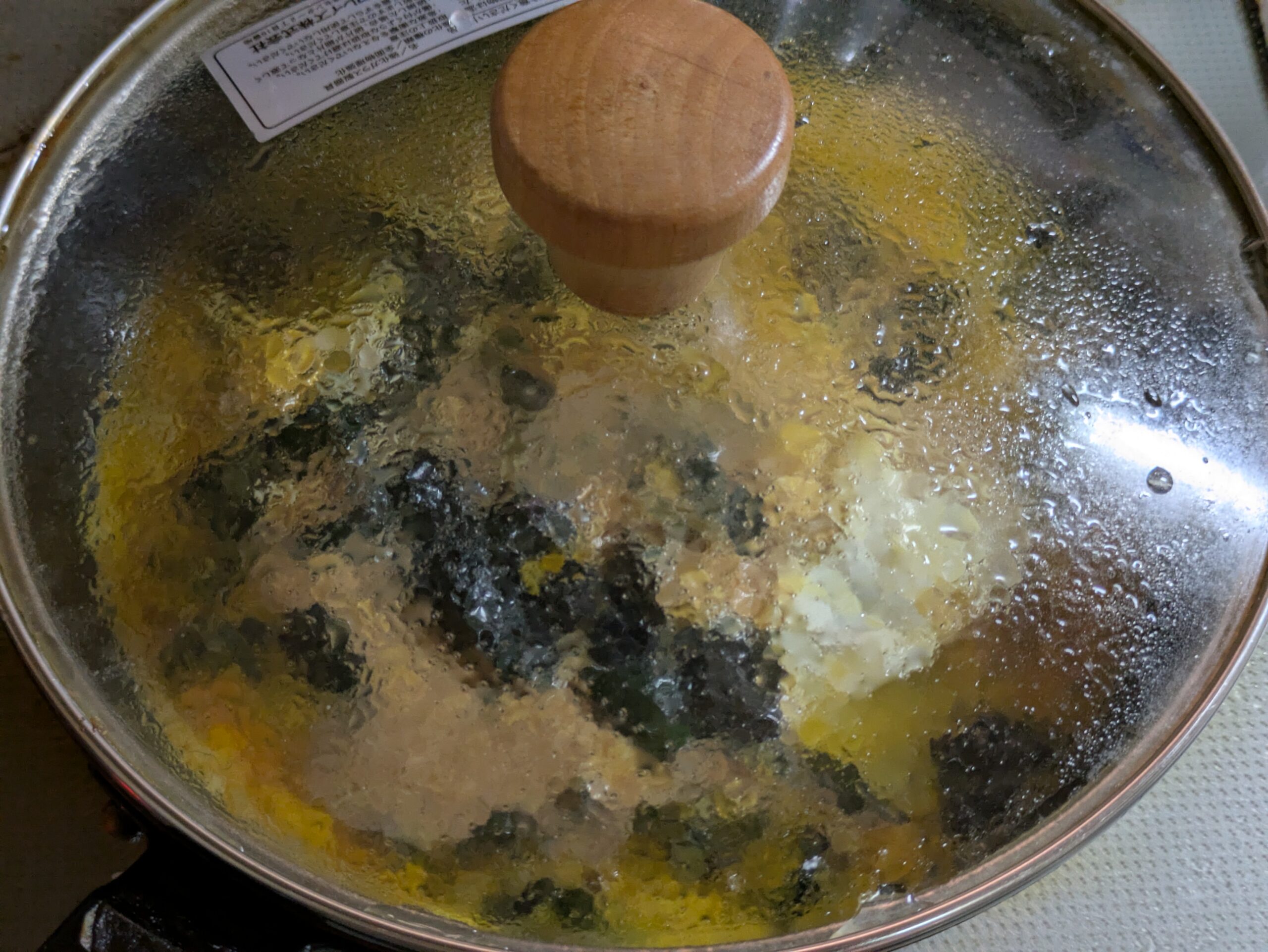 金時草と溶き卵を入れたフライパンにふたをして加熱している様子