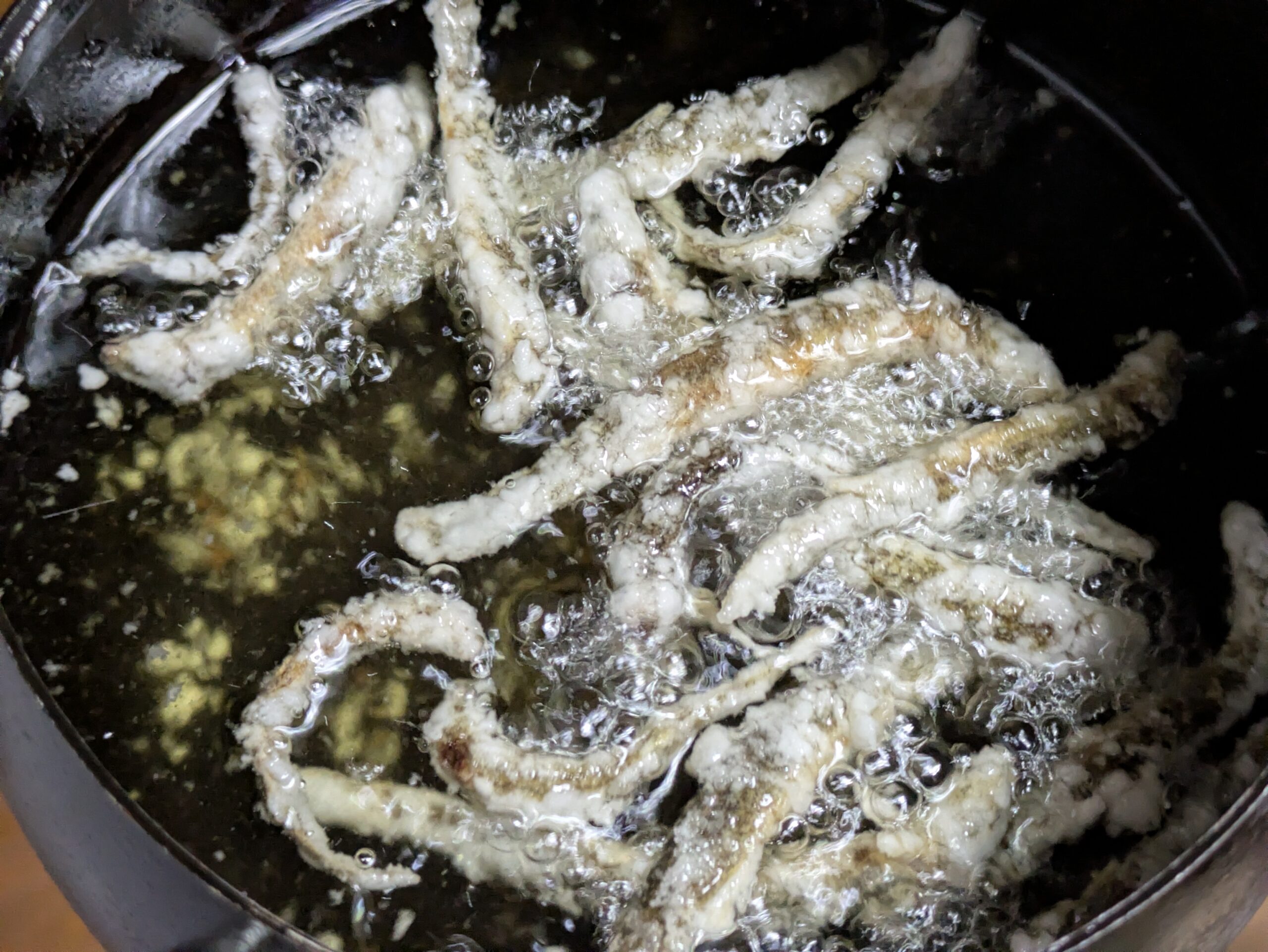 片栗粉をまぶしたドジョウを油で揚げているところ