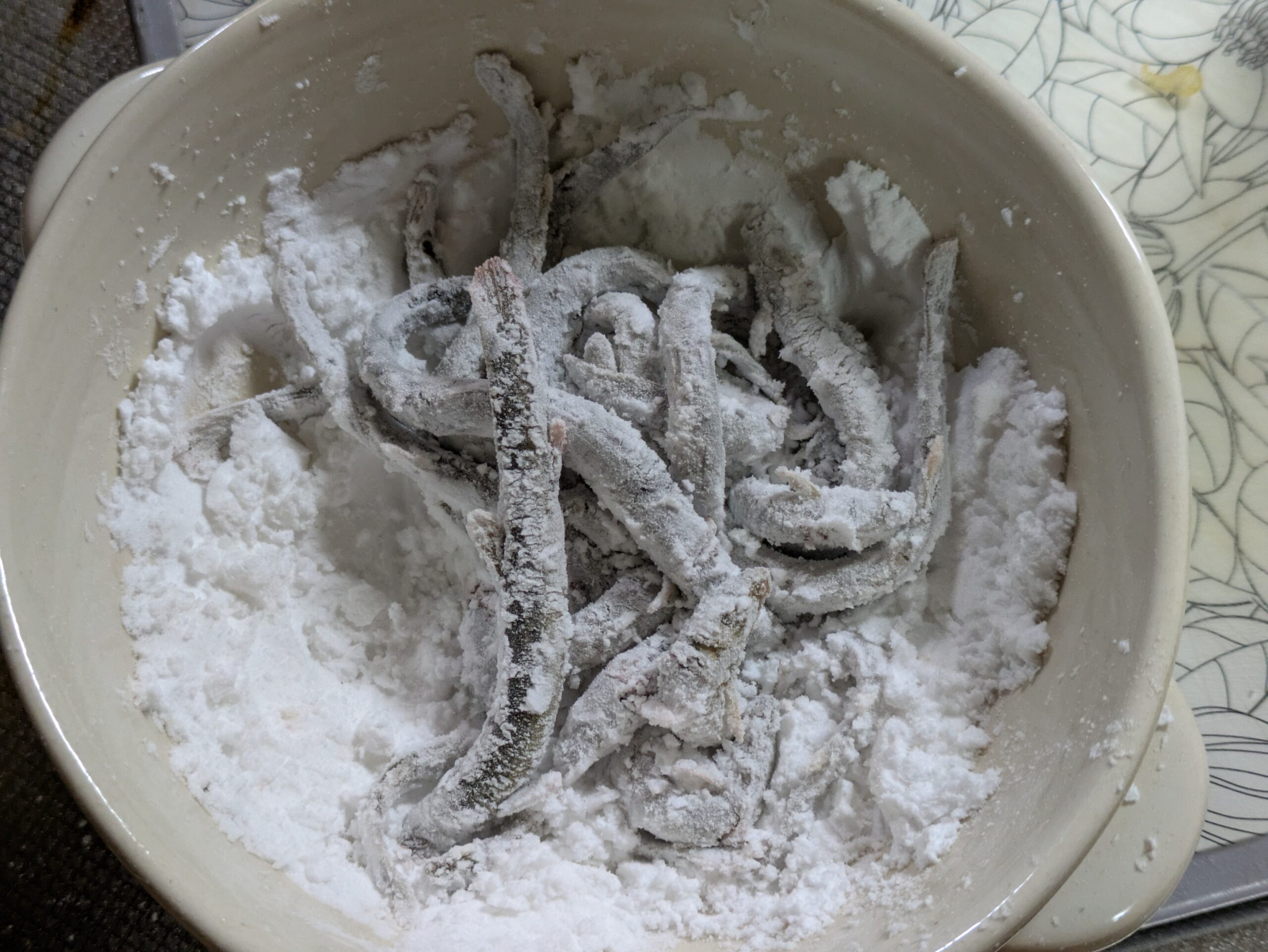 かば焼きにする丸ごとのドジョウへ片栗粉をまぶしたところ