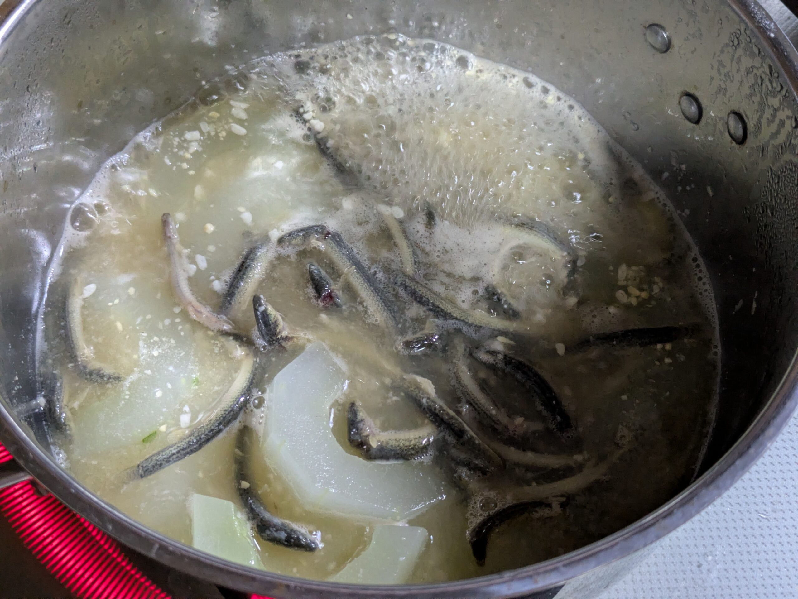ドジョウと下茹でした太きゅうりを味噌と生姜で煮込んでいる様子