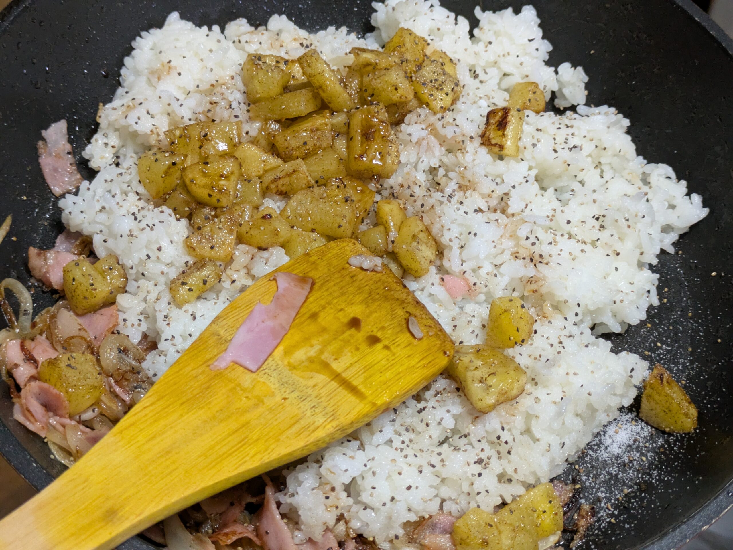 ご飯と焼いたパイナップルをフライパンで炒めている様子