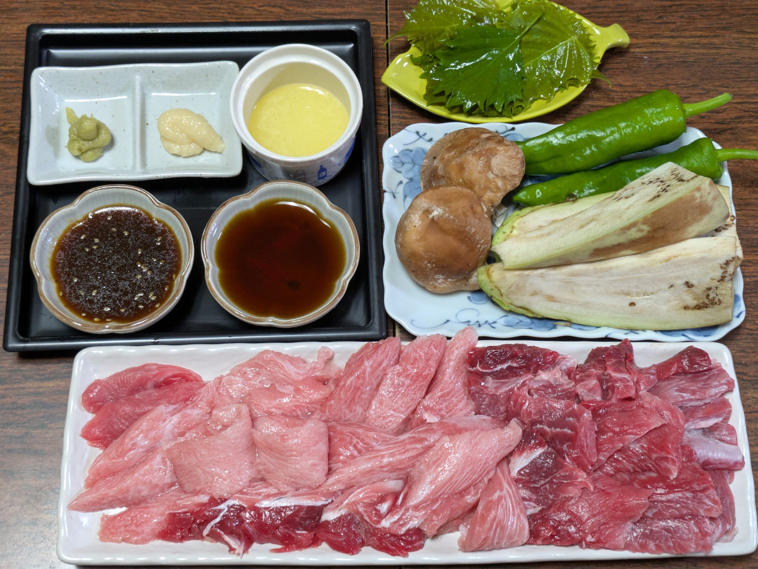 マグロのカマトロとホホ肉、野菜、タレを並べた七輪焼肉の材料