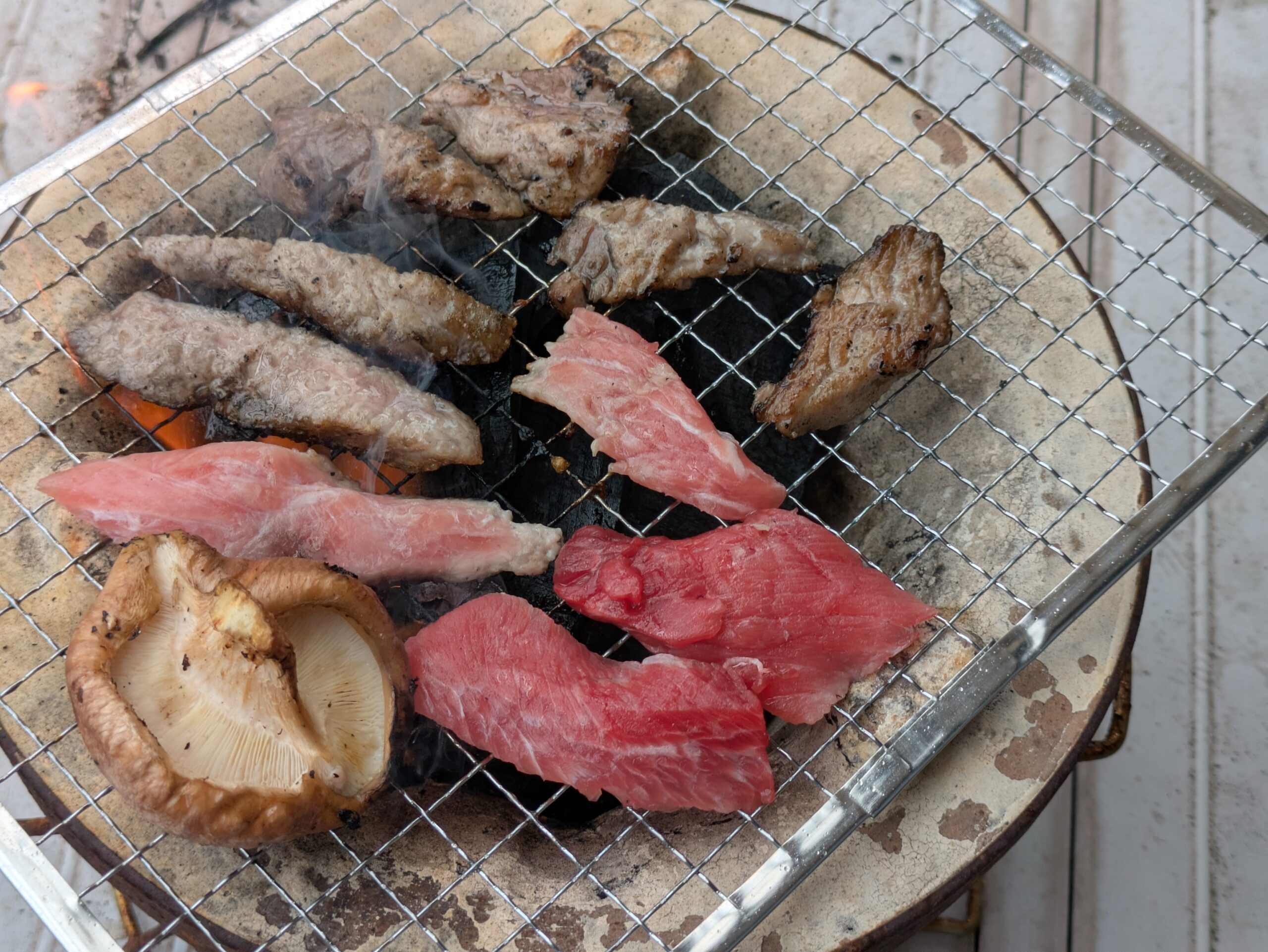 七輪で焼き始めたマグロのカマトロとホホ肉、椎茸