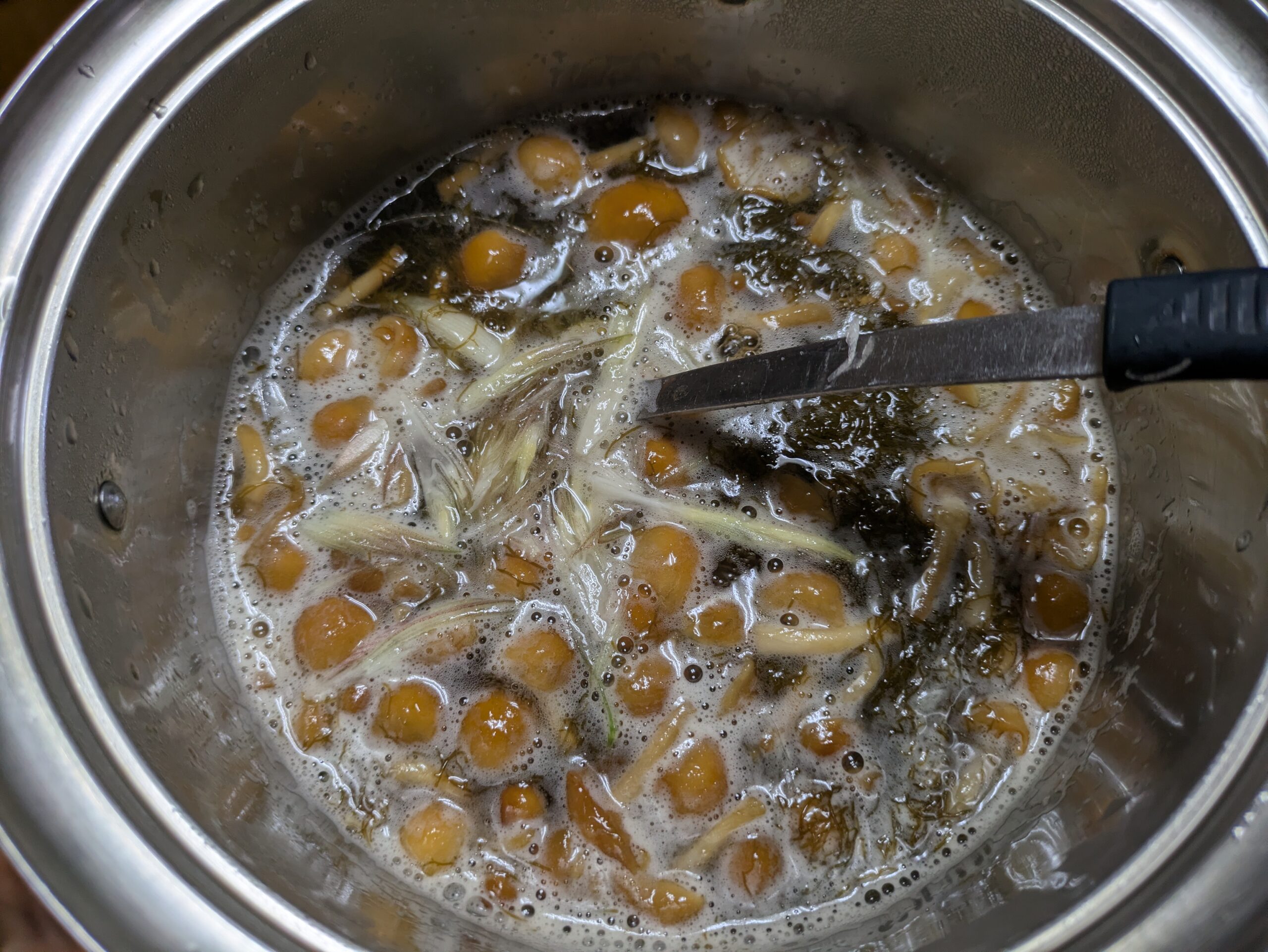 鍋でもずくとなめこのすまし汁を作っている様子