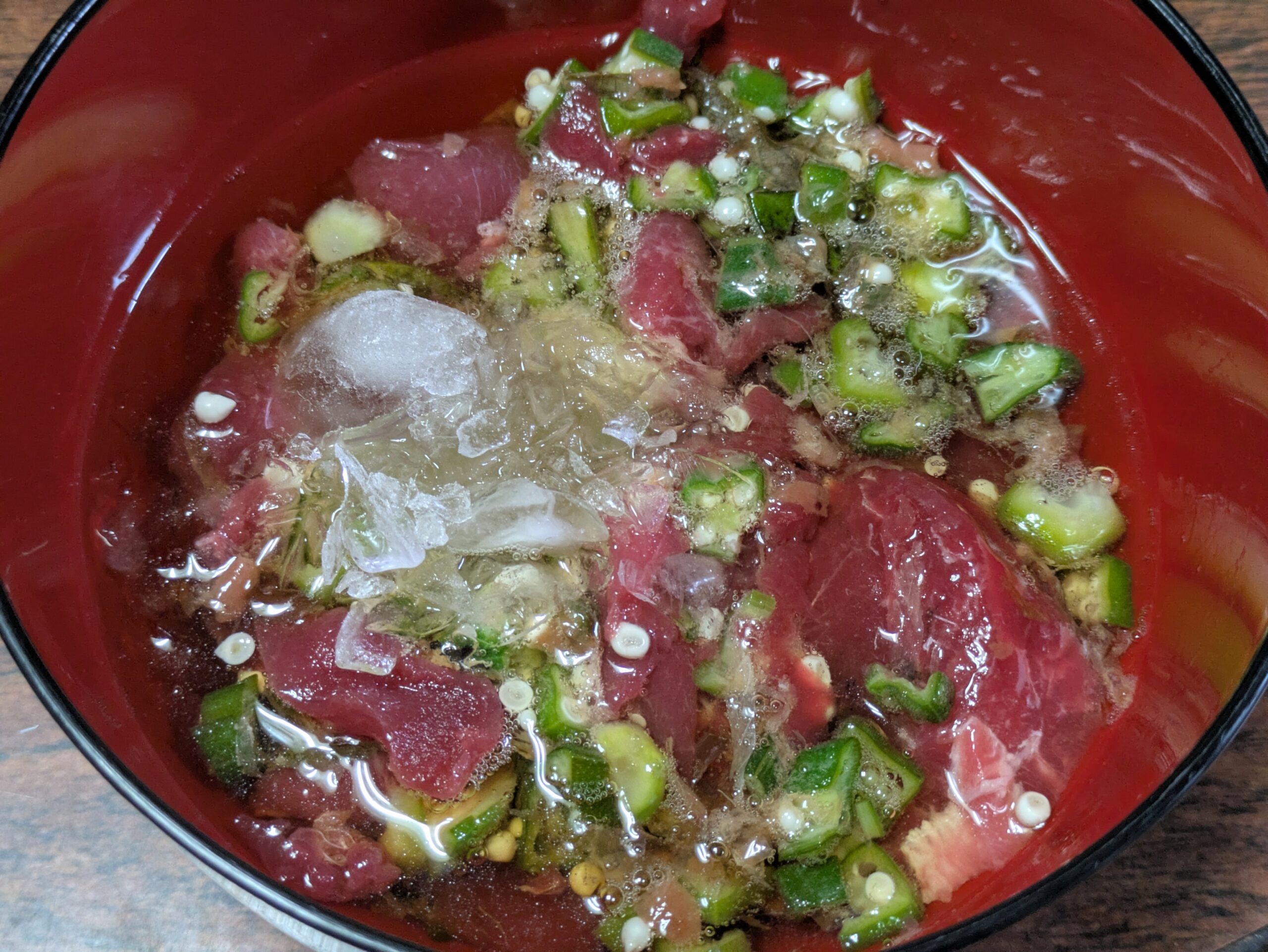 マグロとオクラのたたき和えに冷たい濃縮だしと氷を加えた様子