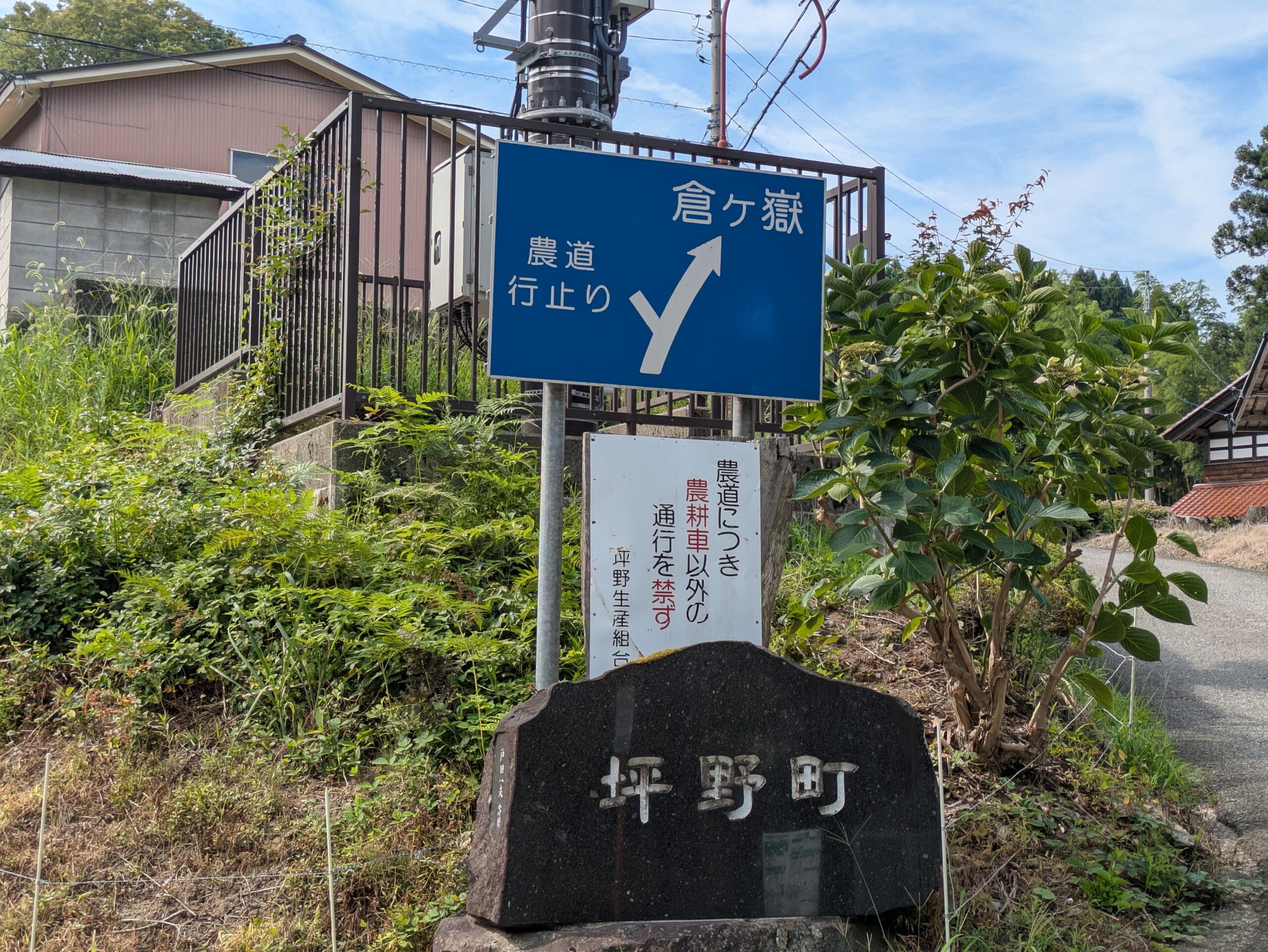 坪野町の入り口にある案内標識と坪野町の石碑