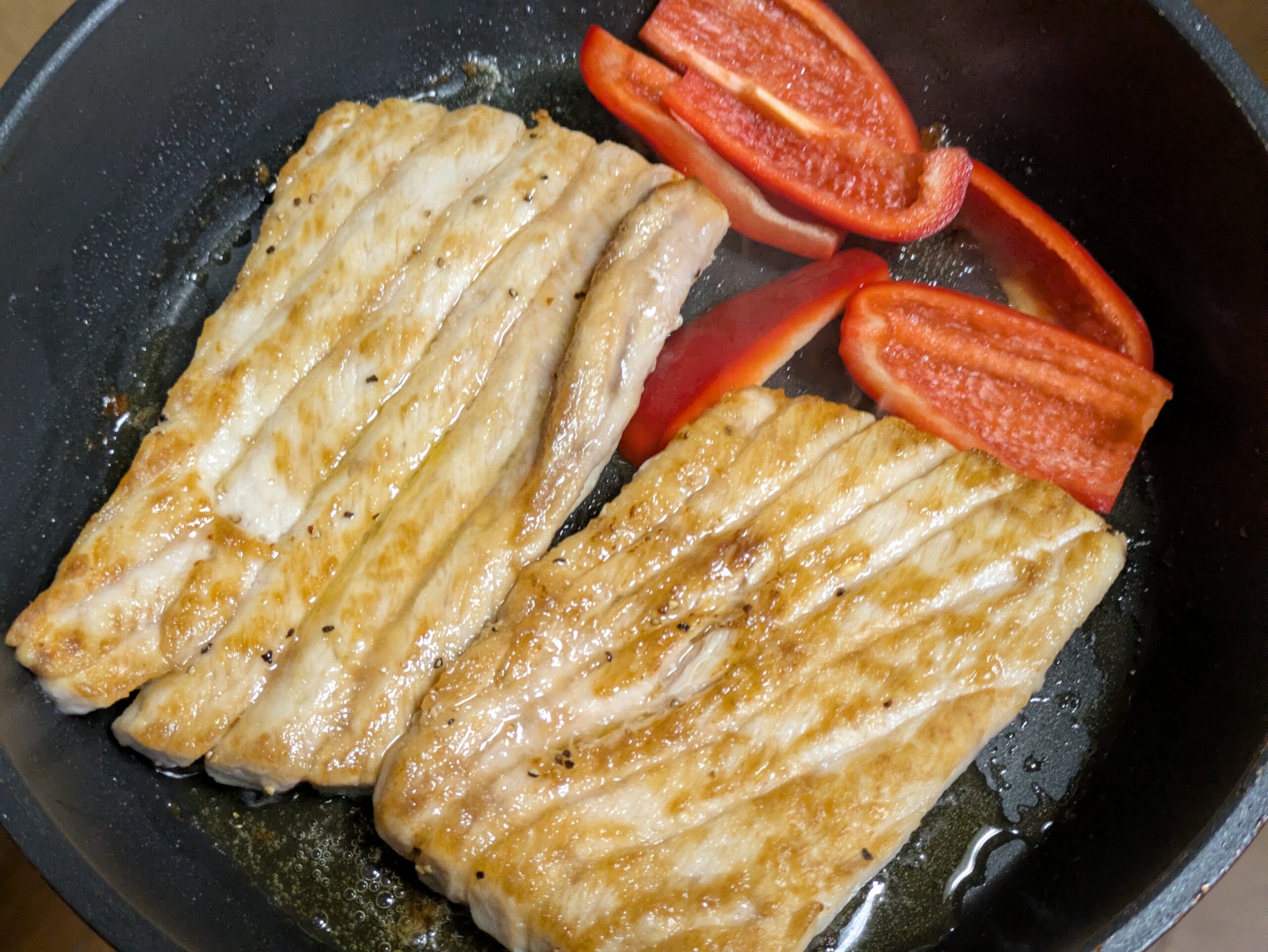 フライパンでカジキの袖と赤パプリカを焼いている様子