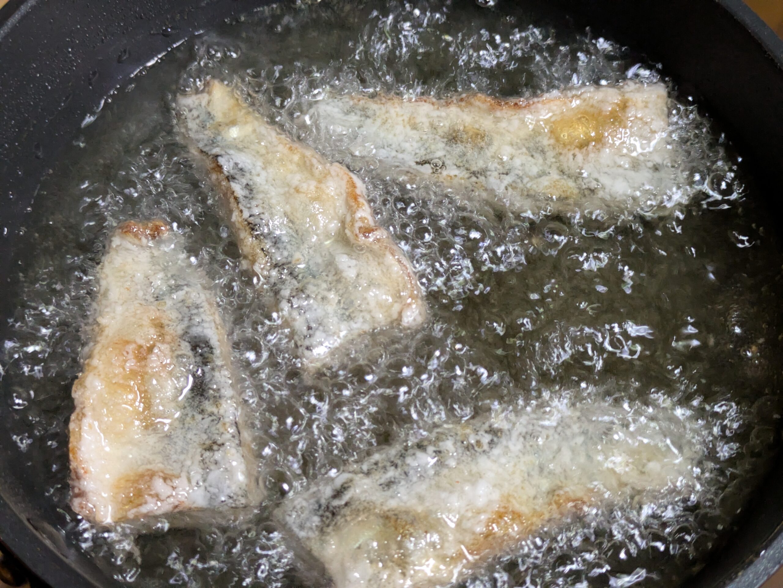180度の油でサンマを揚げている様子