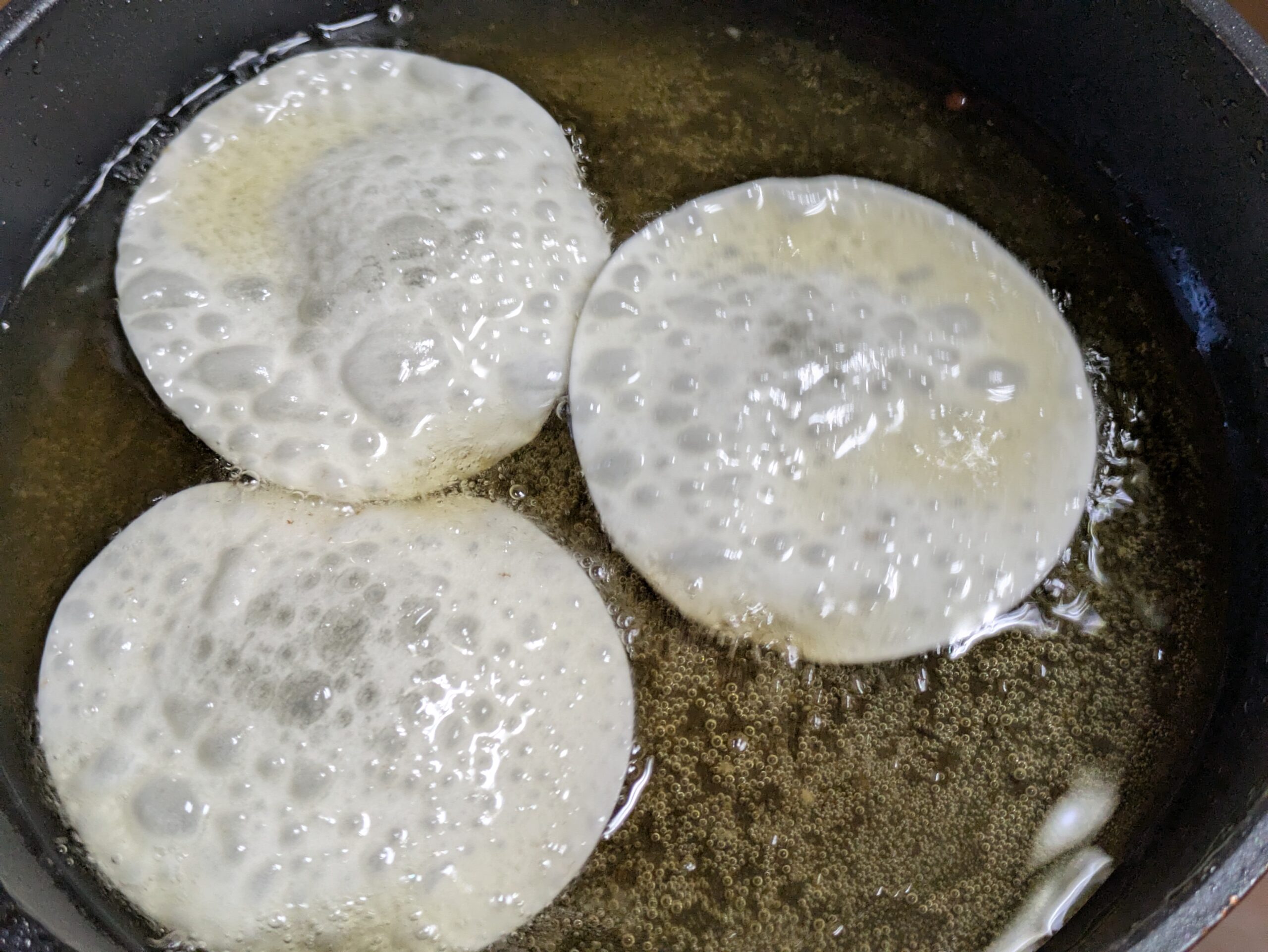 フライパンの油で餃子の皮を揚げている様子