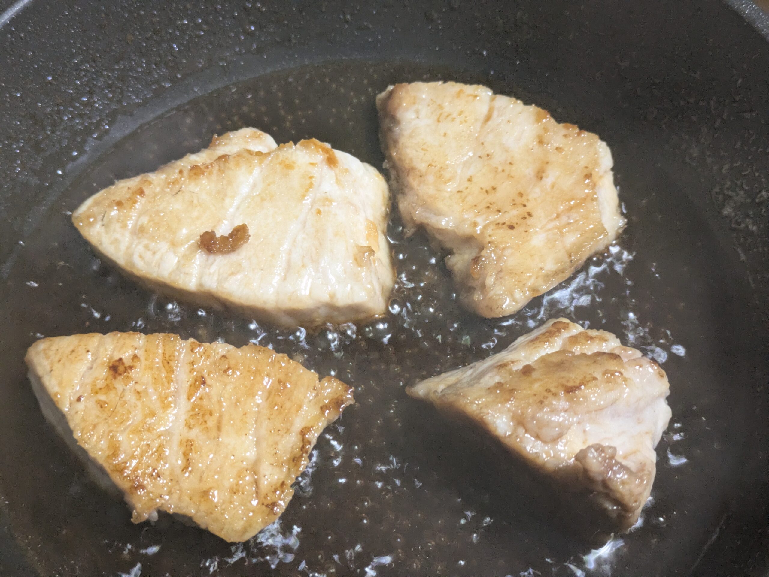 フライパンに照り焼きダレを加えてカジキに絡めている様子