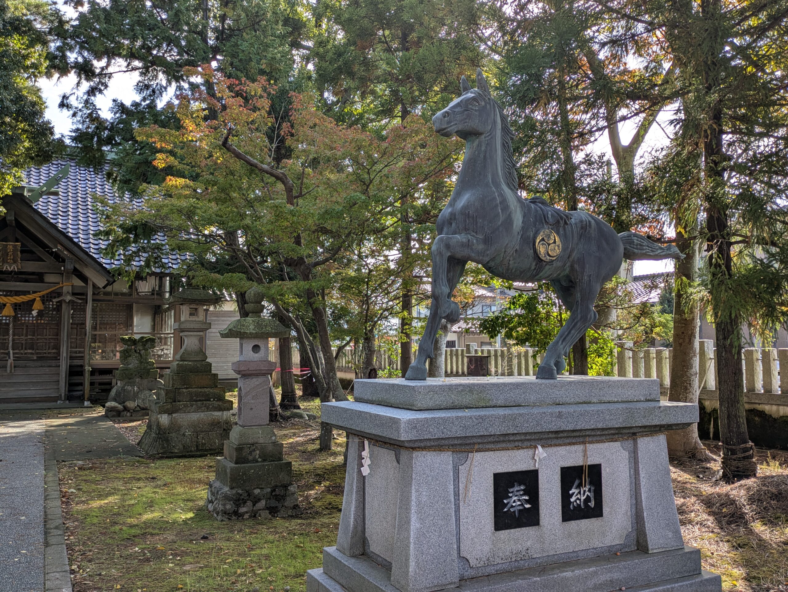 佐那武神社に奉納された前脚を上げた立派な馬の像と奉納の文字がある台座