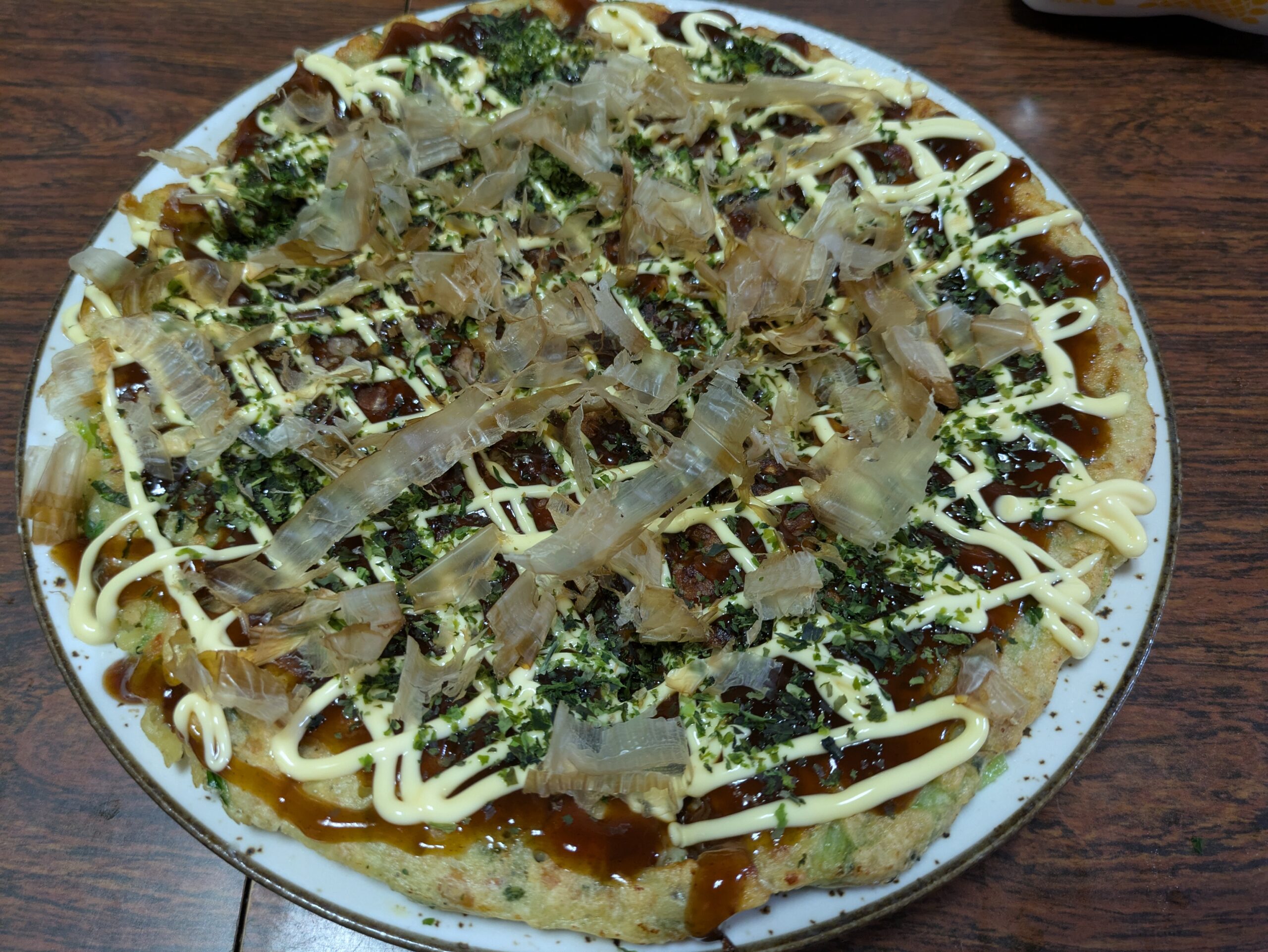 ソースやマヨネーズ、鰹節をかけた納豆と小松菜のお好み焼き