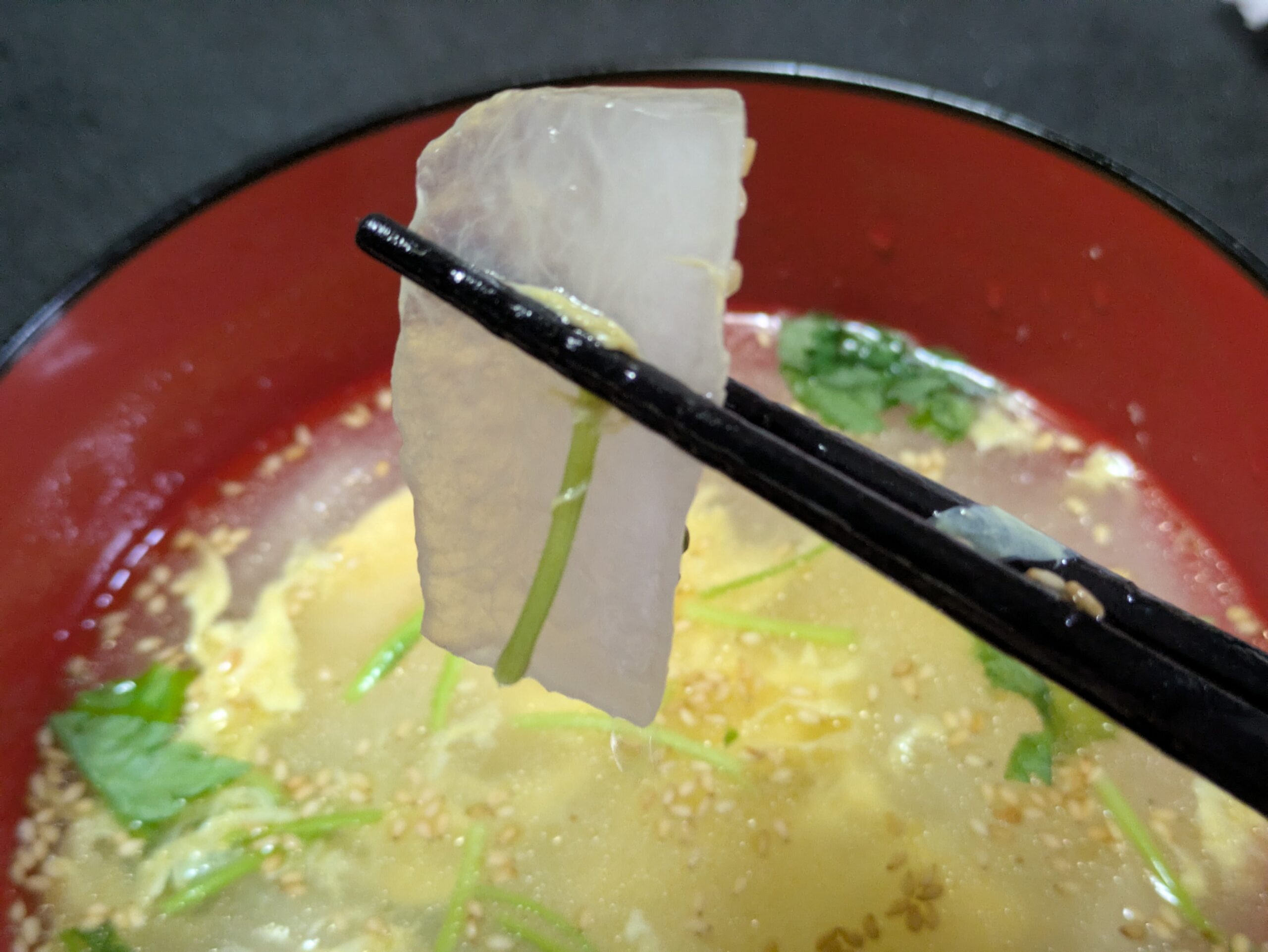 冬瓜と卵の中華風スープの冬瓜を箸で持ち上げた様子
