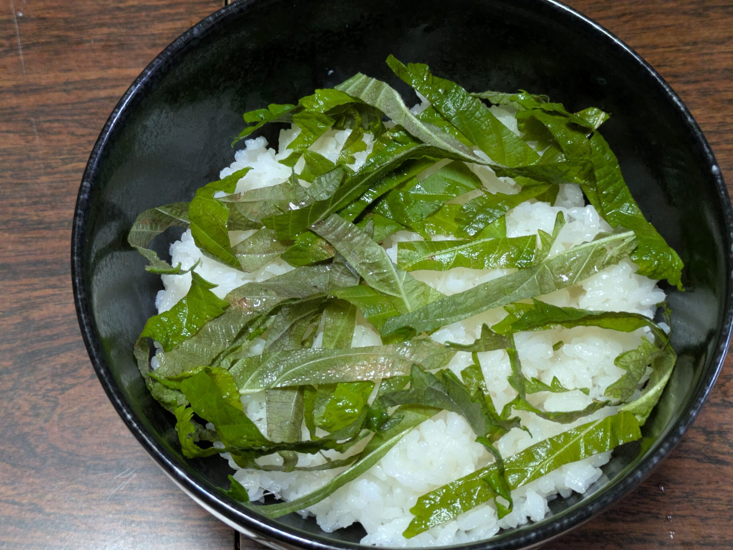 ご飯の上に刻んだ大葉を乗せたユッケ丼