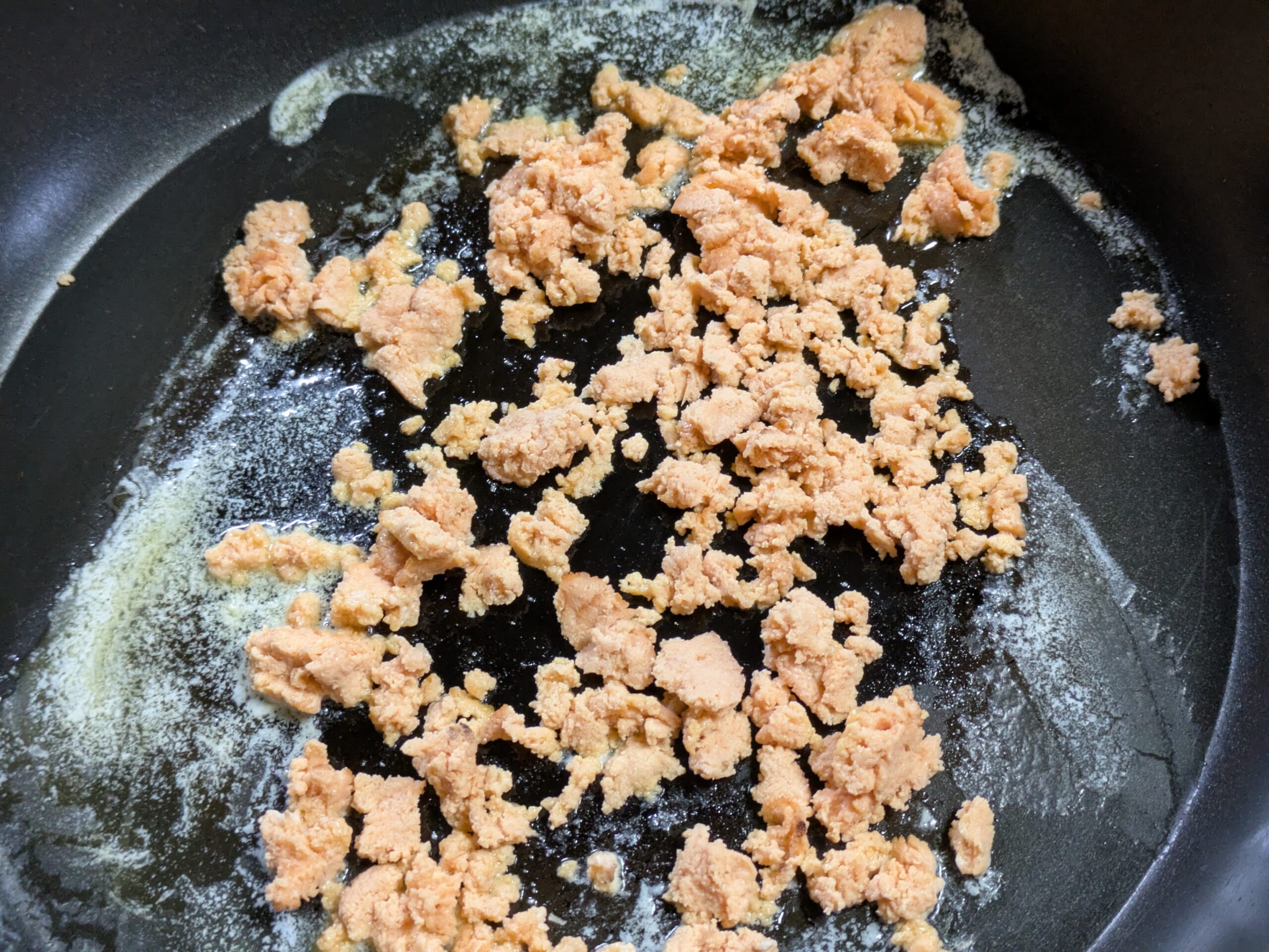 フライパンでマグロの卵をバター炒めにしている様子