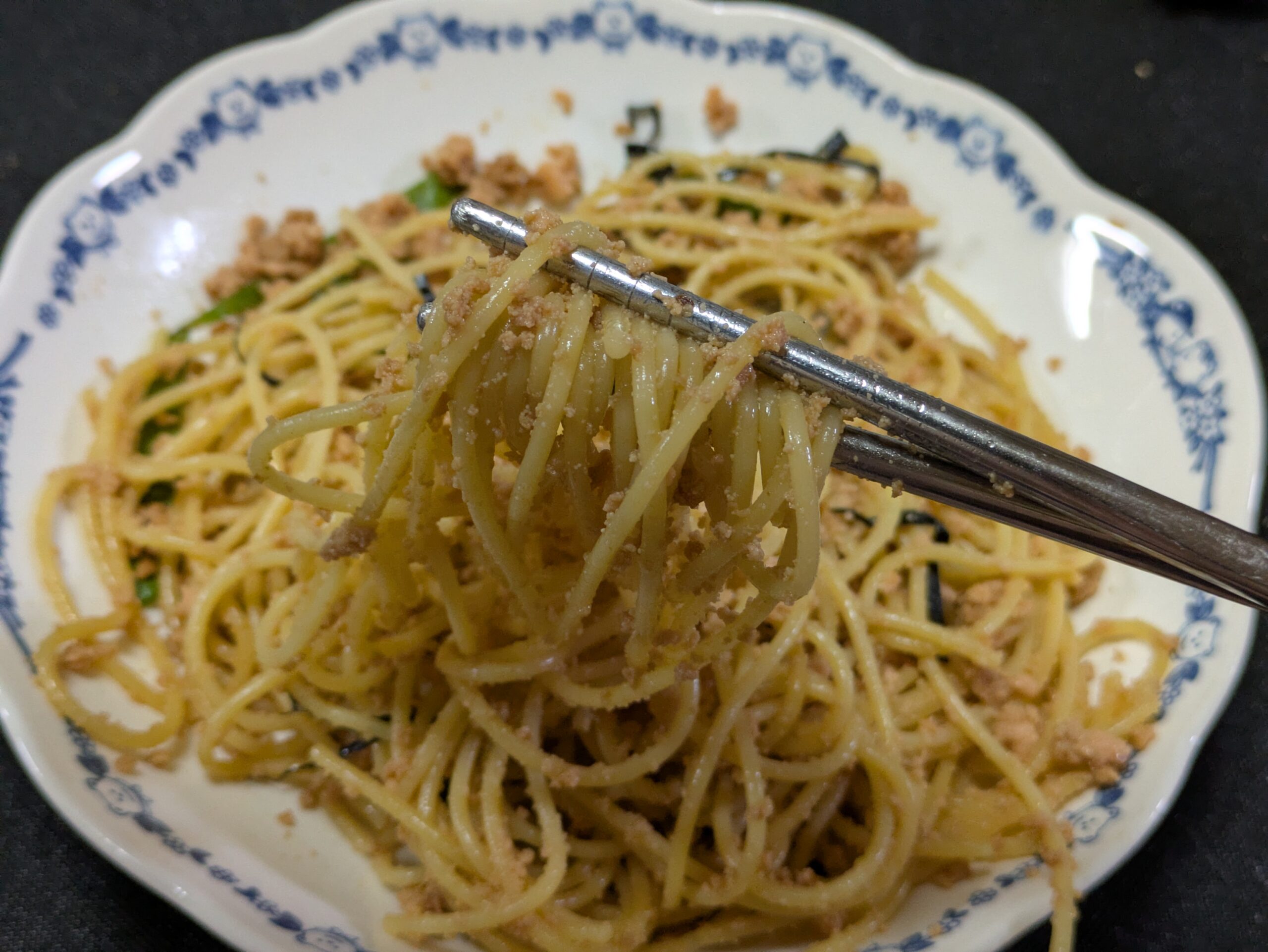 マグロの卵が絡んだ和風バターパスタを箸で持ち上げた様子