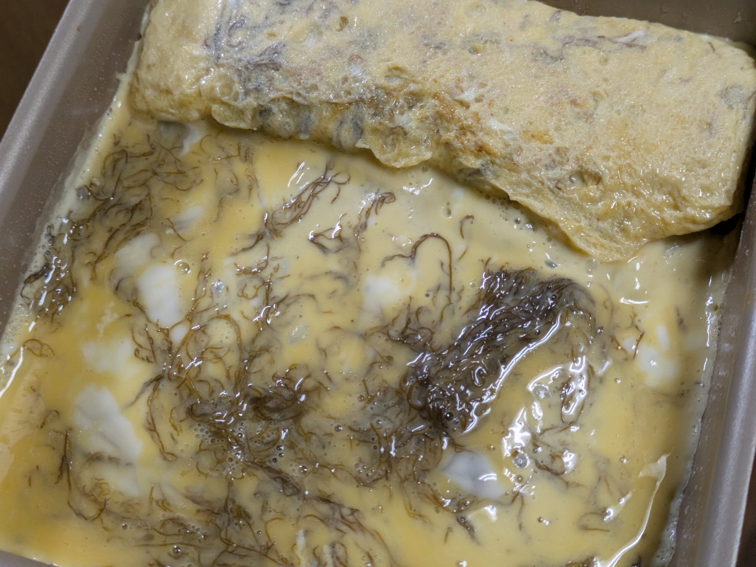 もずく入りの卵液を卵焼き用フライパンで焼く