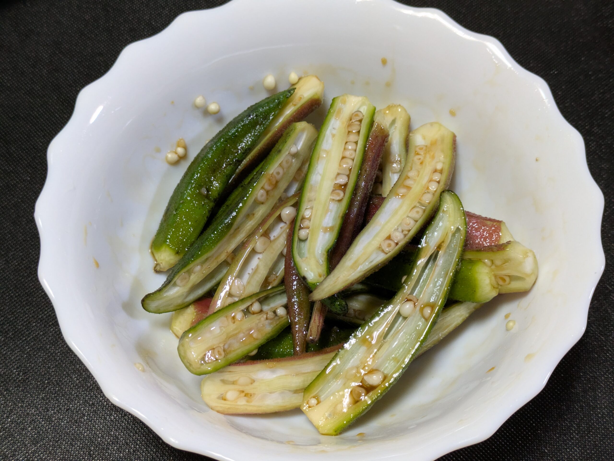赤オクラと青オクラに醤油やにんにくなどの下味を絡めた様子