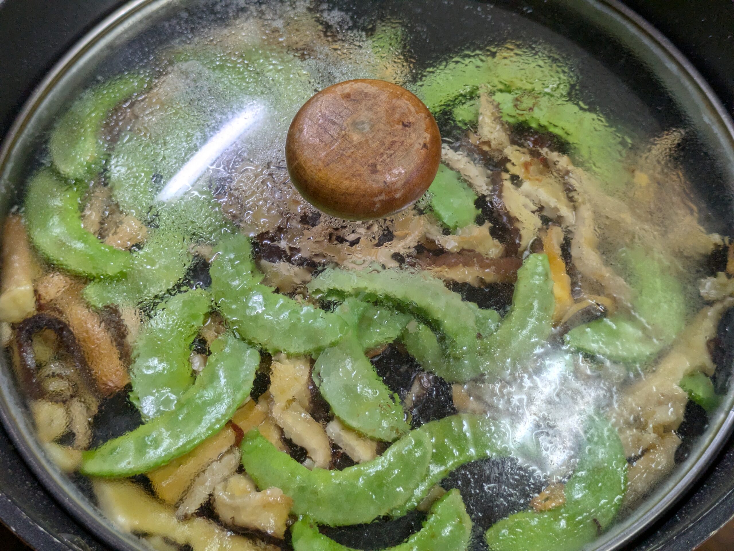 加賀つるまめと百万石しいたけをフタをして蒸し焼きにする様子