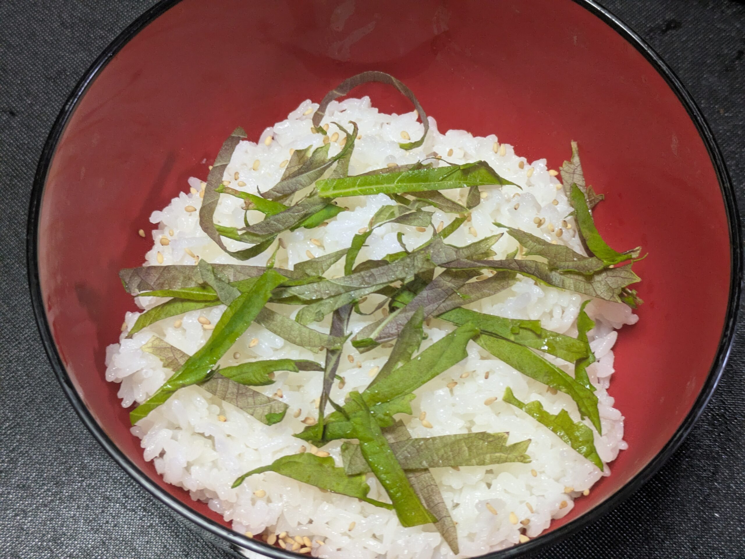 丼のご飯に刻んだ大葉と白ごまをのせた様子