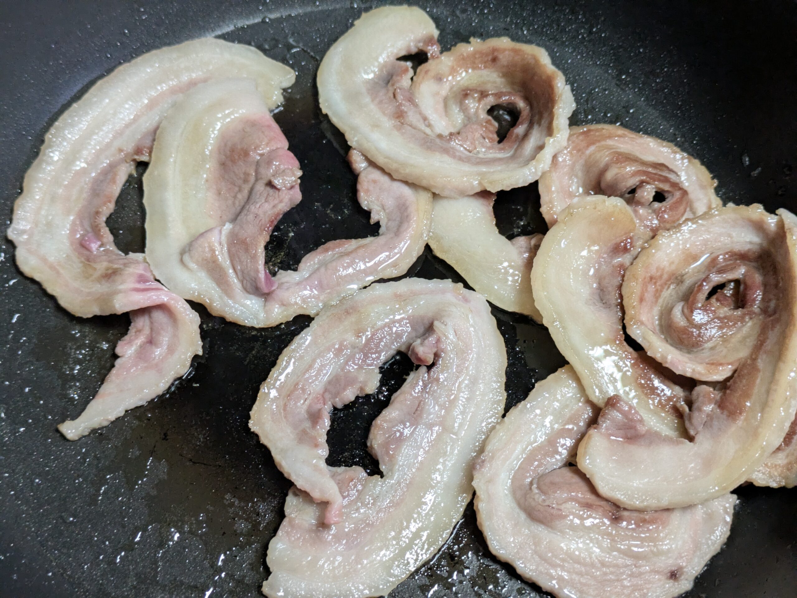 フライパンで焼いているイノシシのバラ肉