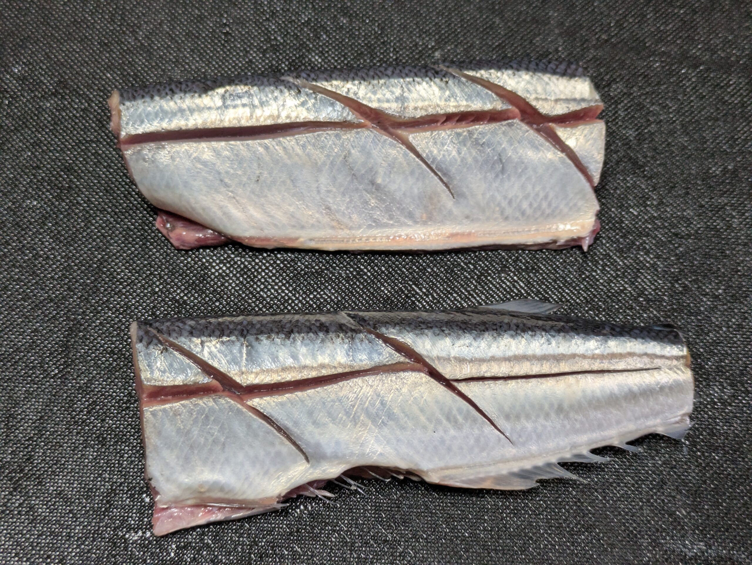 頭と内臓を取って半分に切ったサンマ
