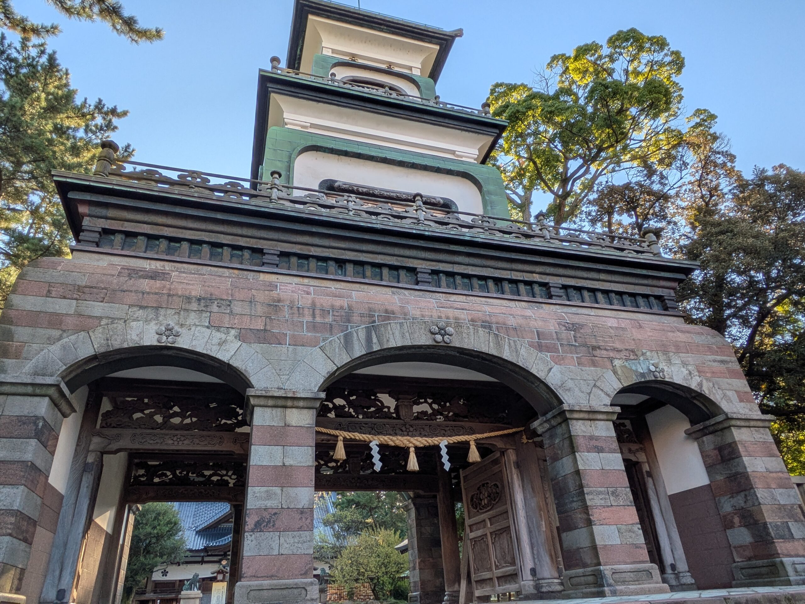 尾山神社の神門を下から見上げた様子と石造りのアーチ
