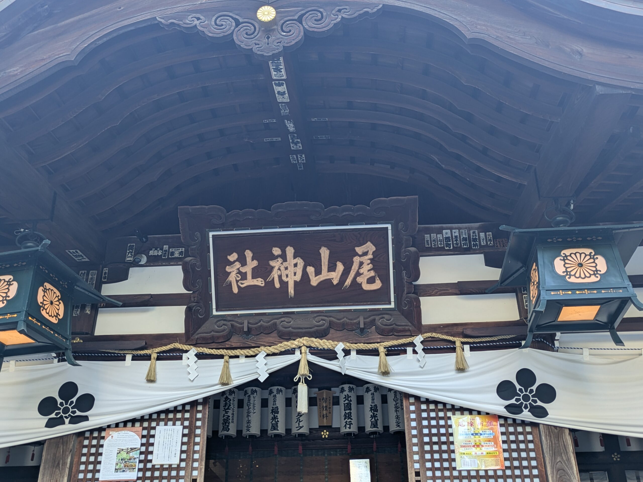 尾山神社拝殿の社名額と梅鉢紋の入った幕