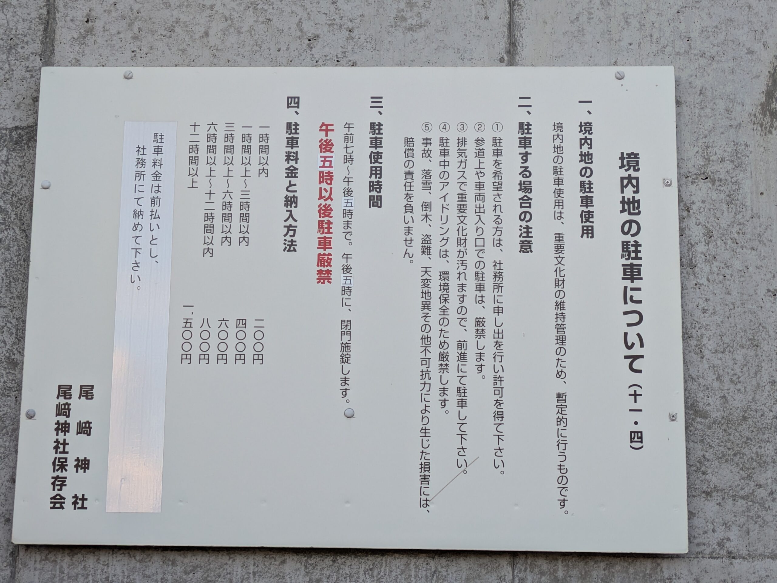 尾崎神社の境内駐車場の利用時間と駐車料金を記した案内板
