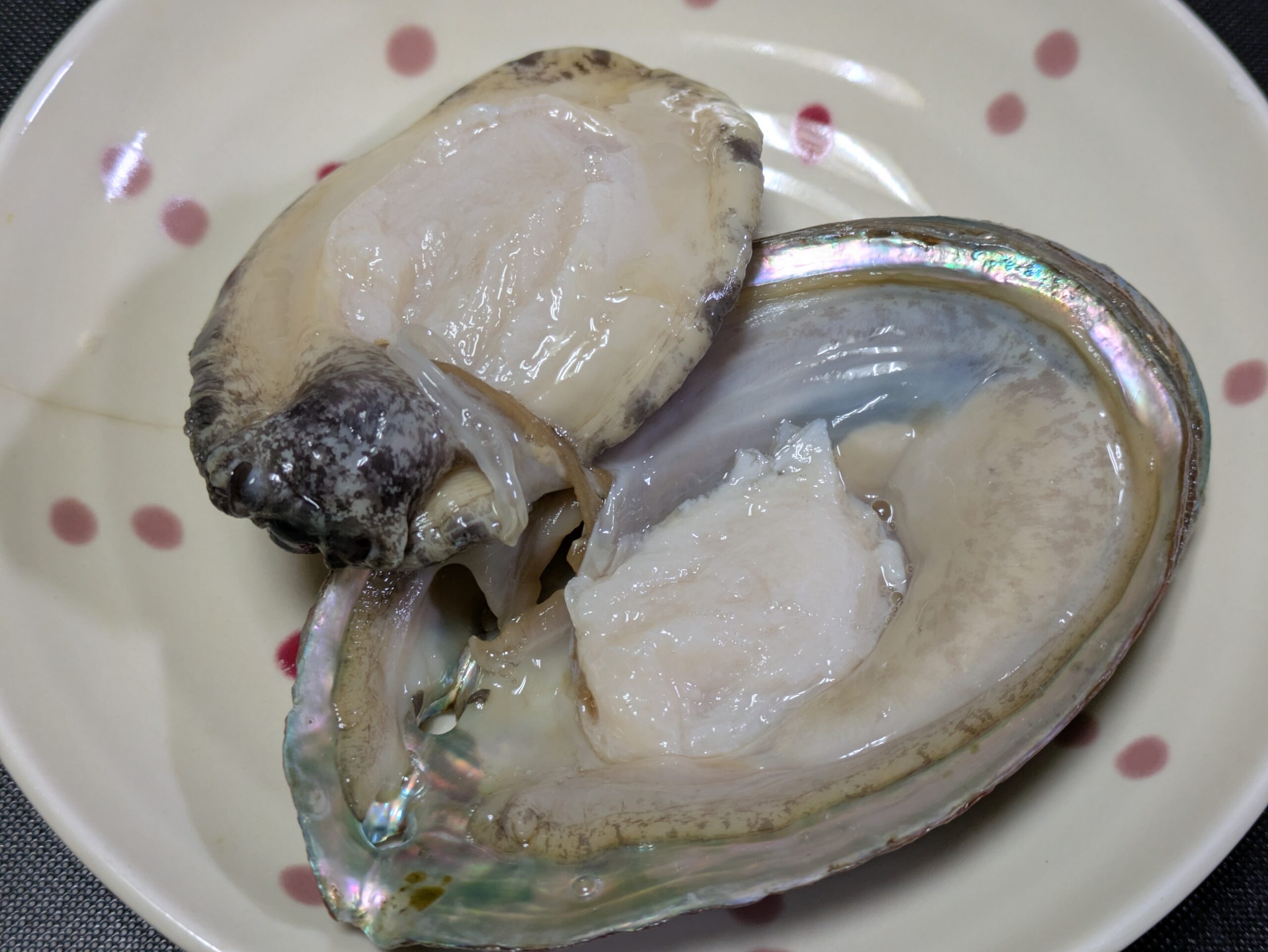 殻から身が一部外れたアワビ