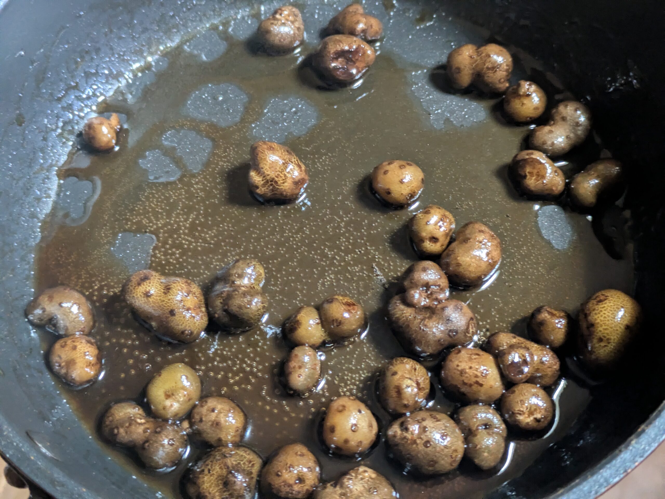下茹でしたむかごを甘辛いバター醤油で炒める様子