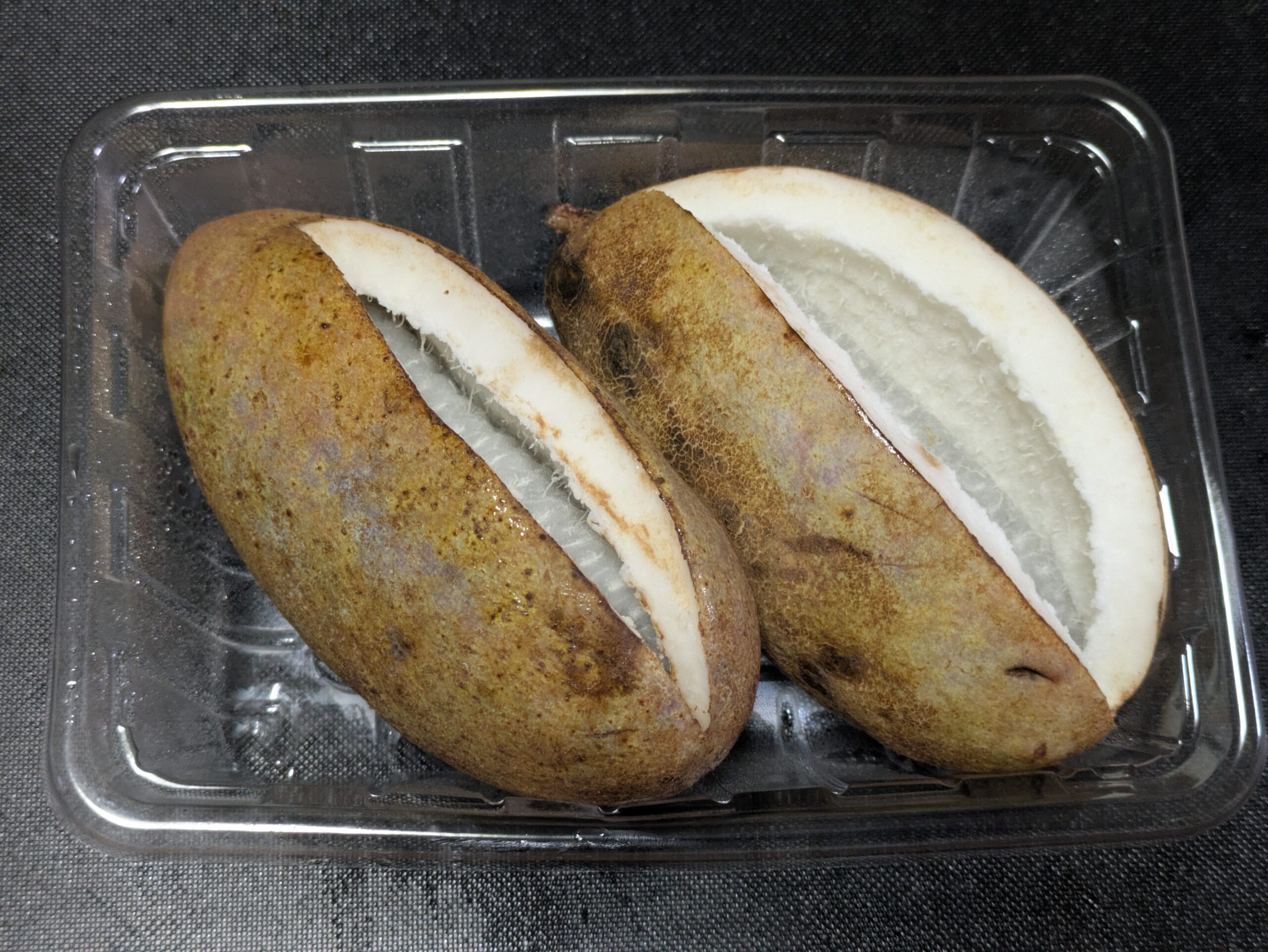 スーパーで購入した茶色い皮が割れたアケビの果実2個