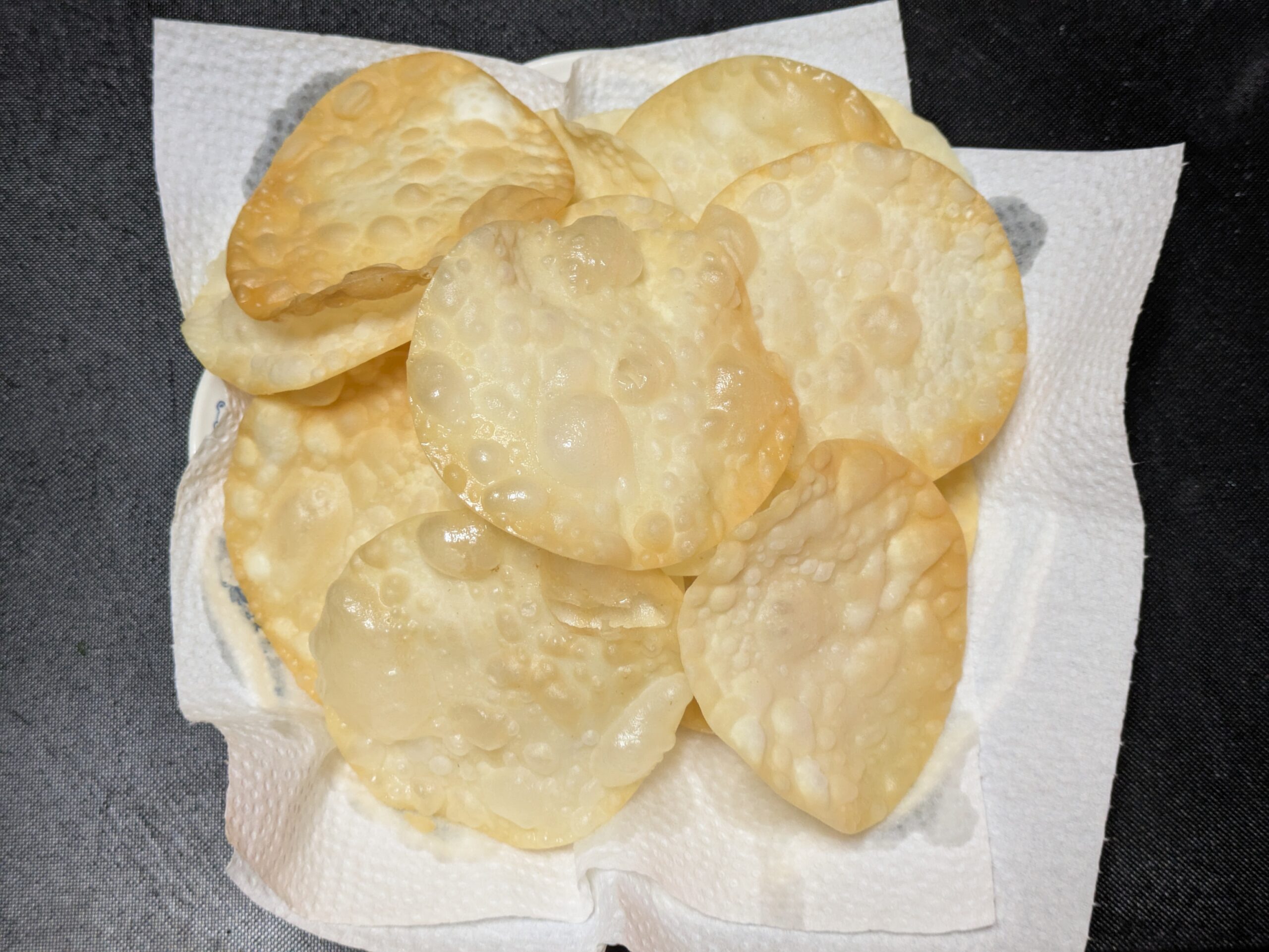 揚げた餃子の皮チップスをキッチンペーパーの上に並べた様子