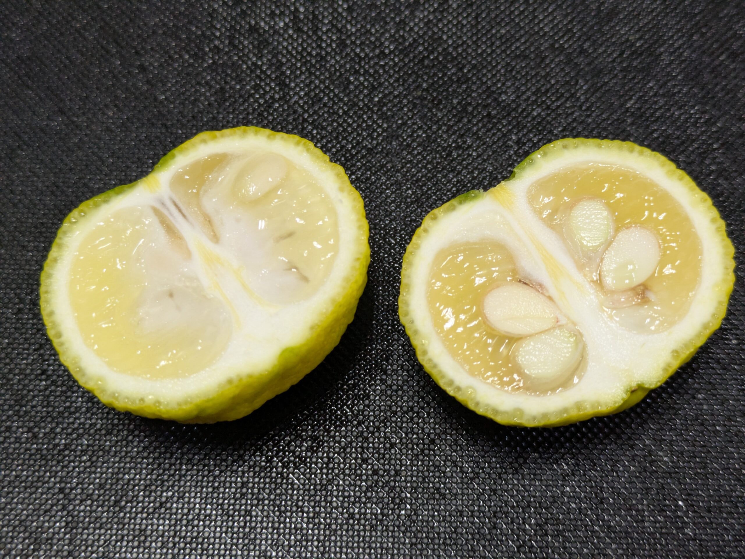 半分に切った柚子の断面と中に入った大きな種