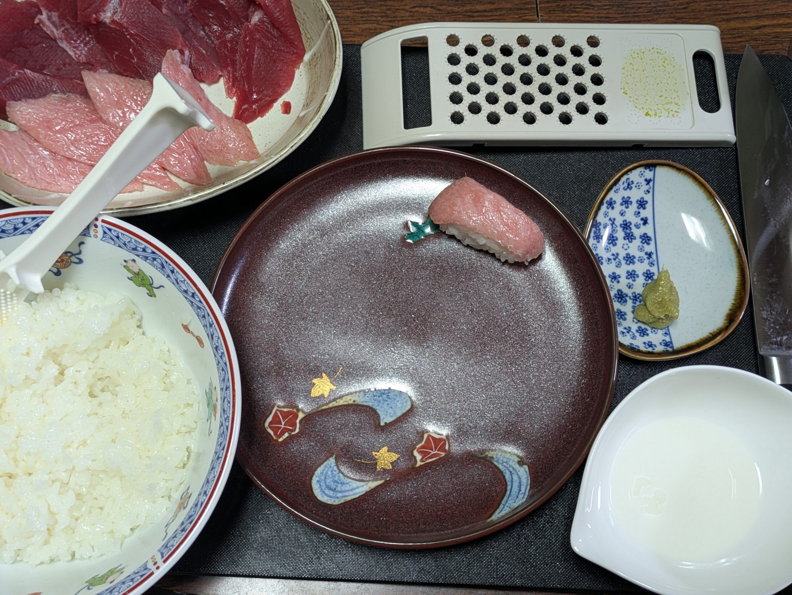 マグロの赤身とトロ、酢飯、わさびを並べた手作り寿司の準備風景