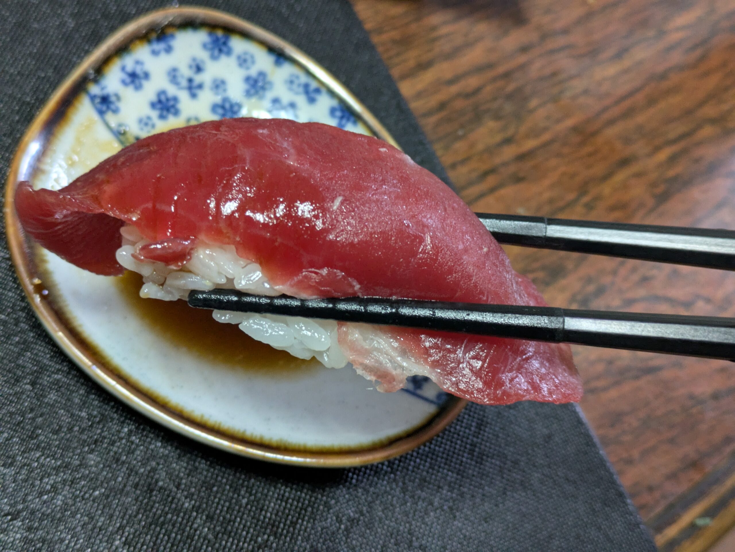 箸で持ち上げたマグロ赤身の手作り握り寿司