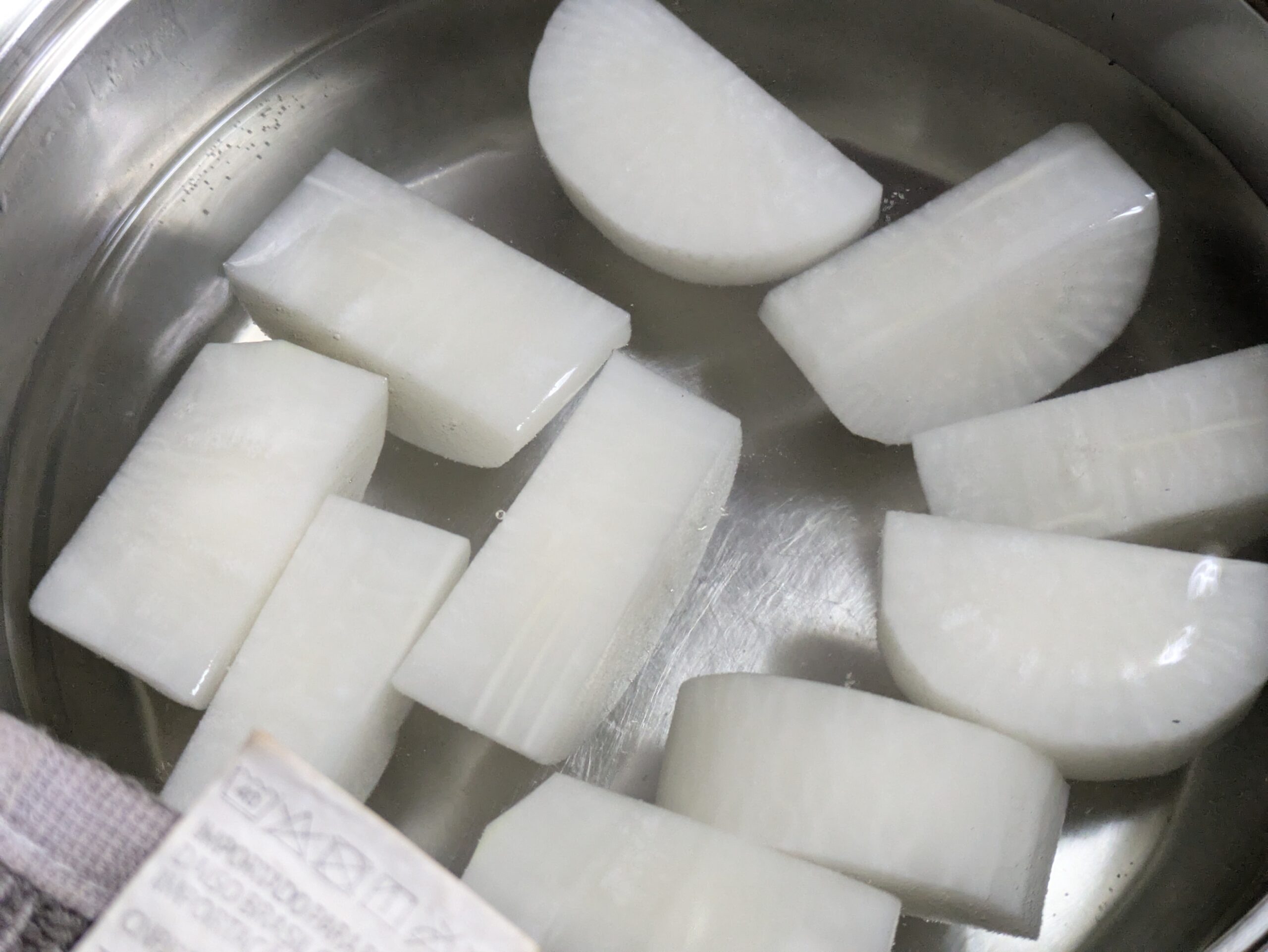 鍋に水と金沢大根を入れて下ゆでしている様子