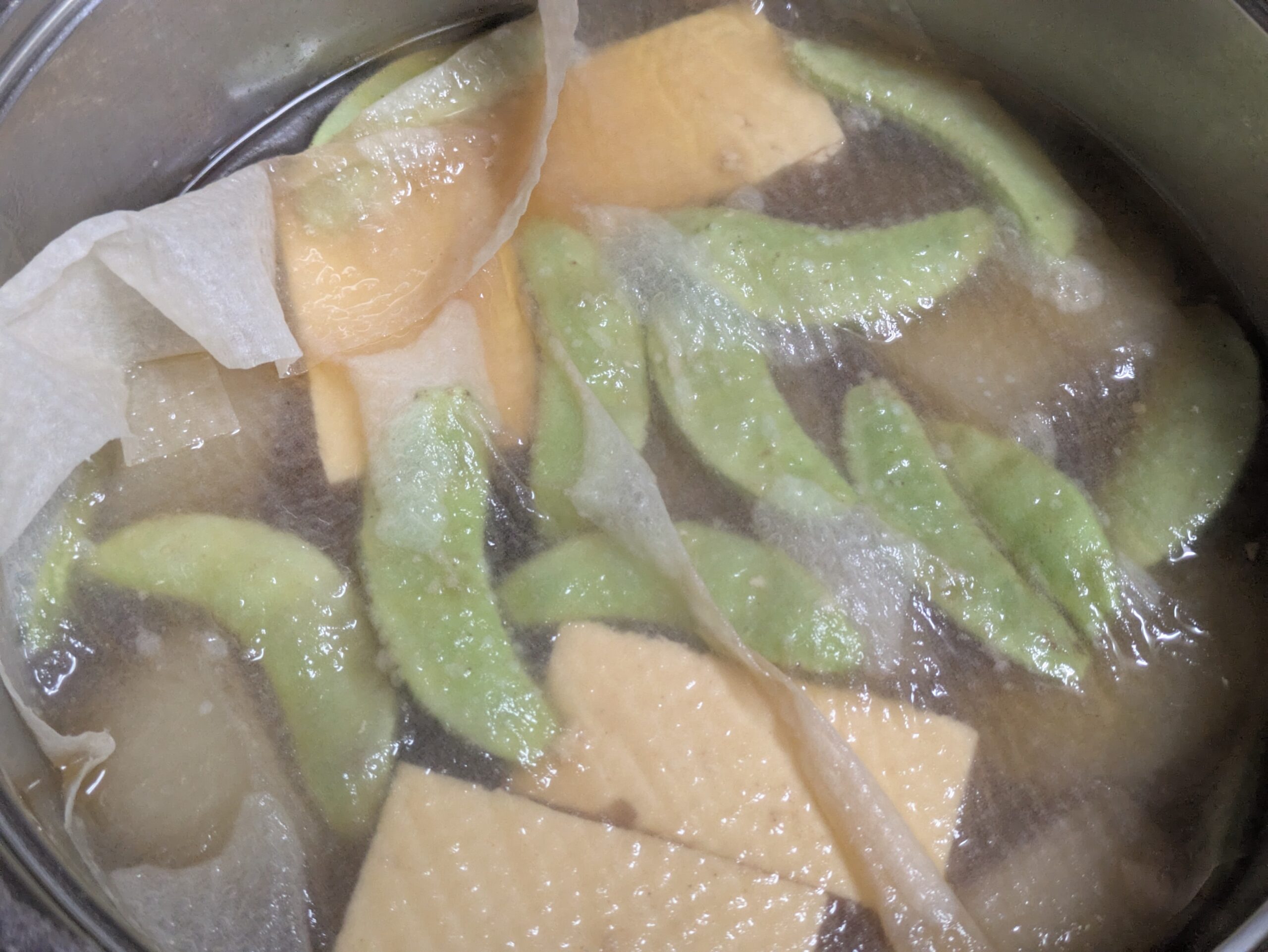 金沢大根と木綿豆腐の煮物に加賀つるまめを加え落とし蓋で煮込む様子